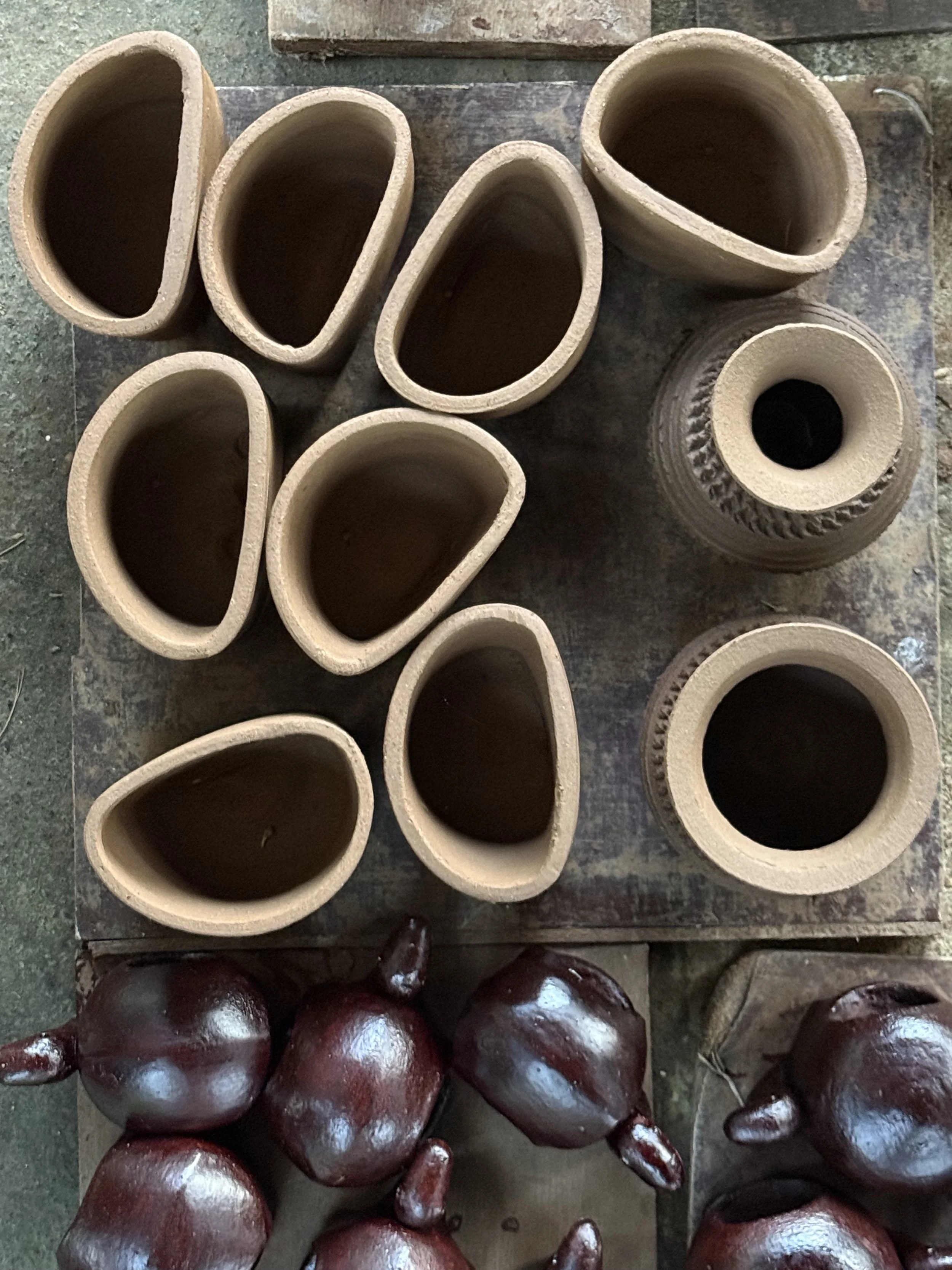 Handmade clay pots arranged on a wooden surface.