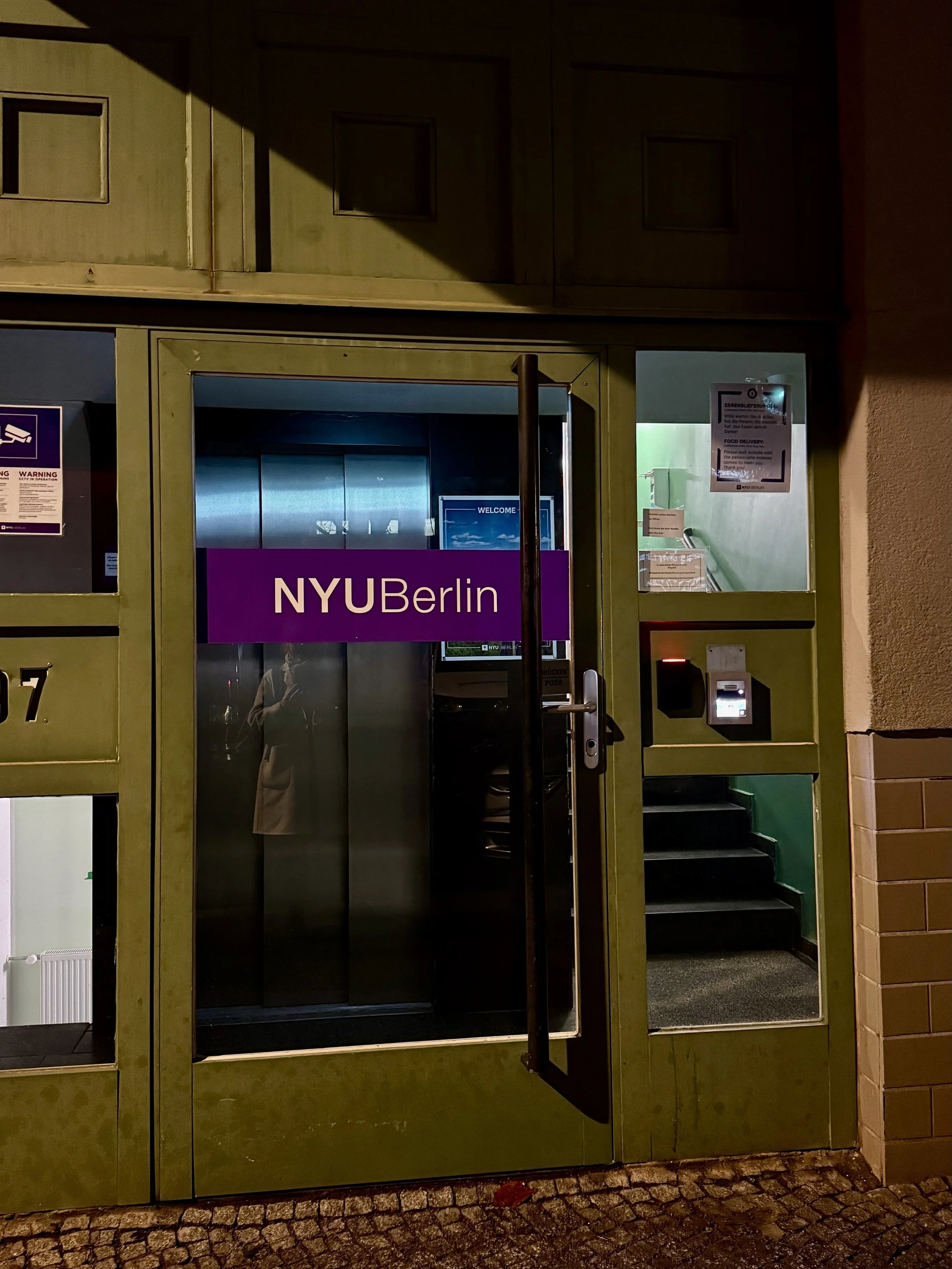 Green door with purple sign reading NYUBerlin