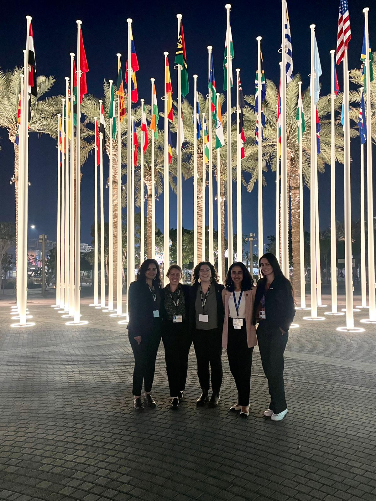 Aarushi, Selena, Alyssa, Shubhangi, and Alexandra in front of flags.png