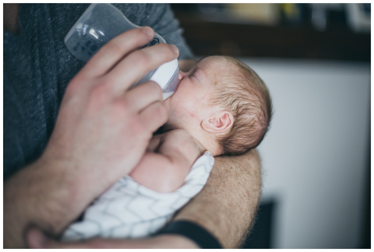 dad feeds baby bottle