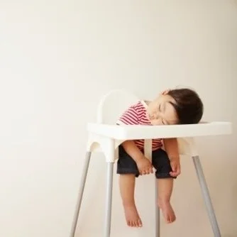 sleeping baby in high chair.jpg