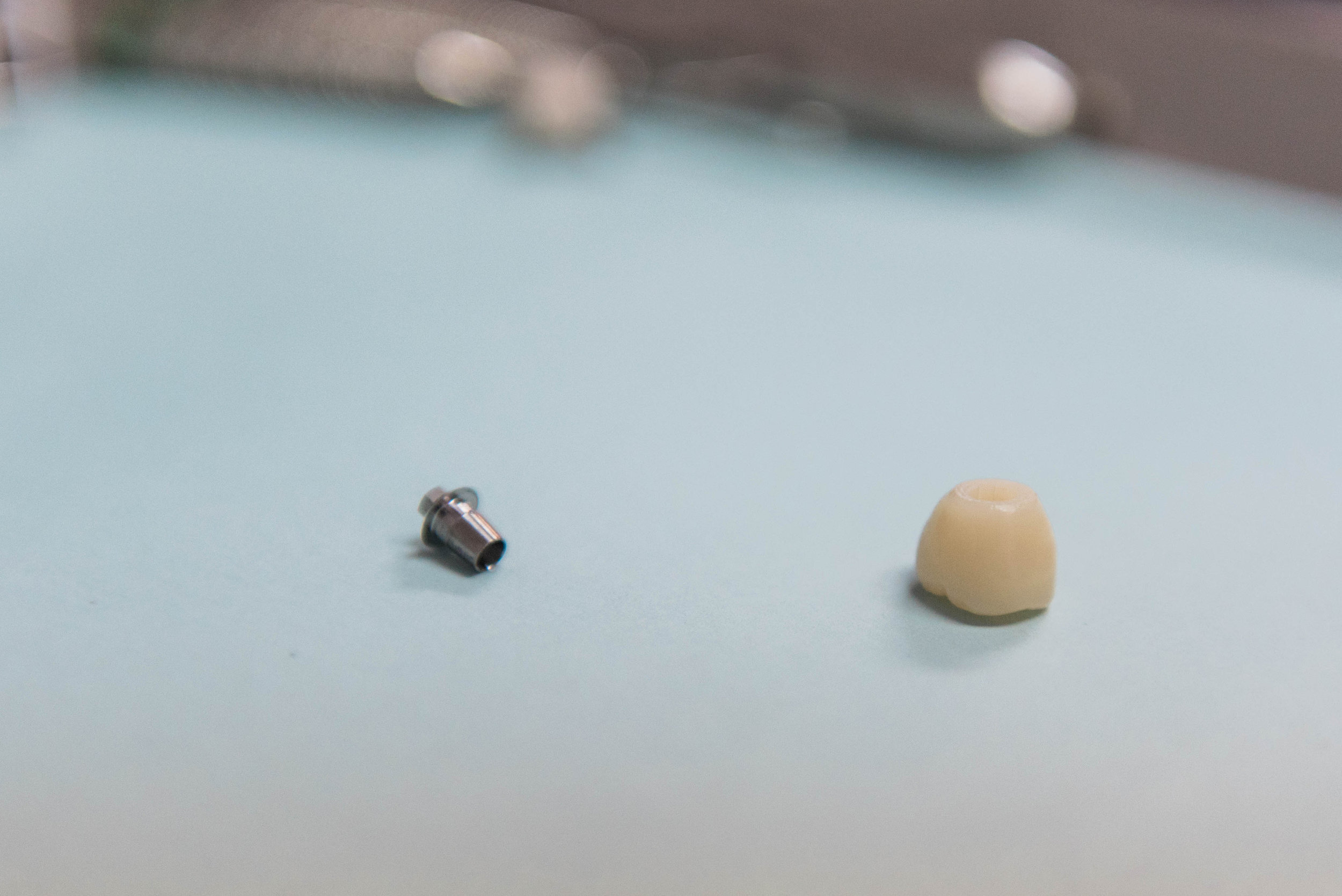 The base of an implant is a titanium column, atop of which sits an abutment, which will connect the column to a dental crown.