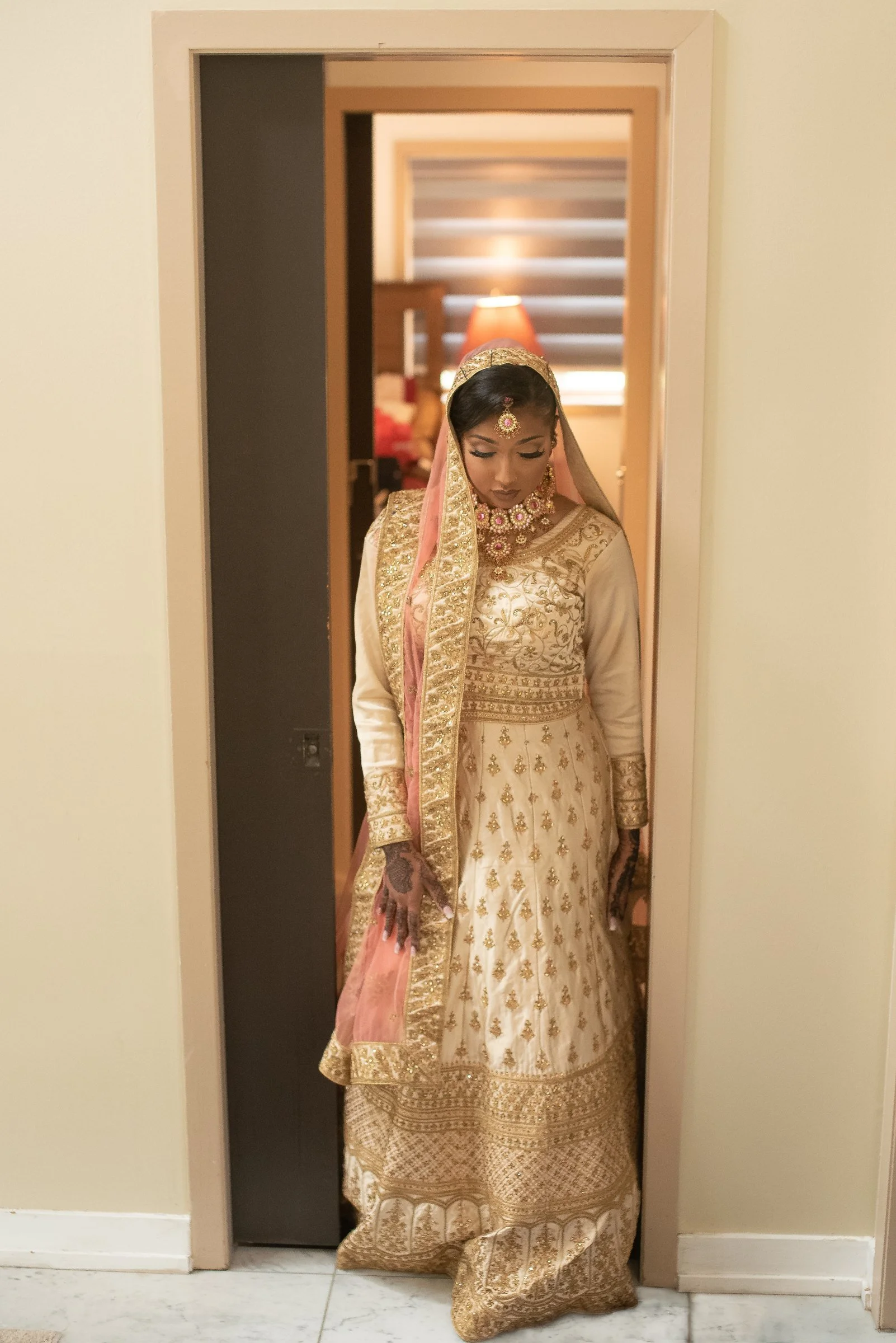 Zonera standing in the hallway in her wedding outfit