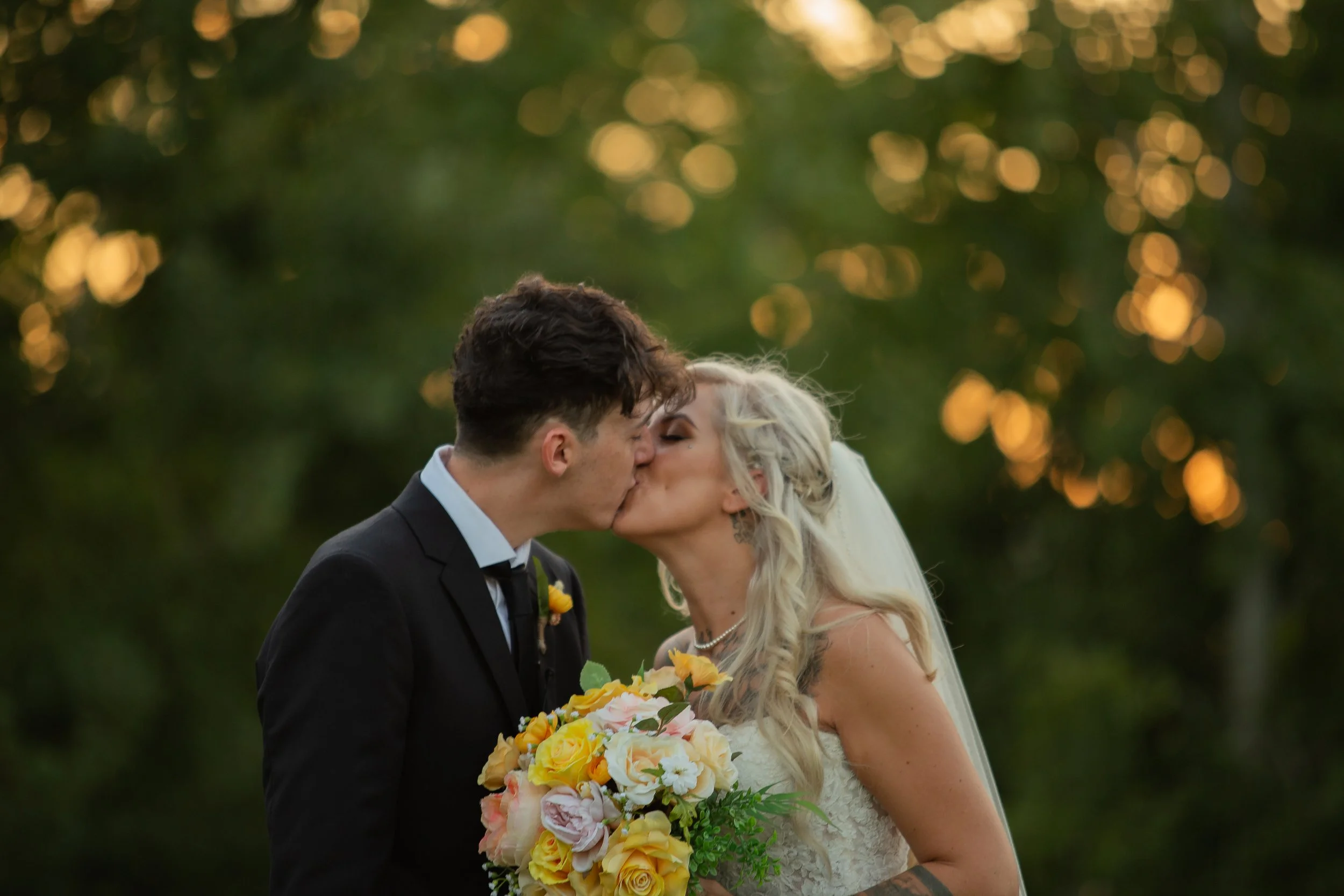 A newly married couple sharing a kiss in the evening light