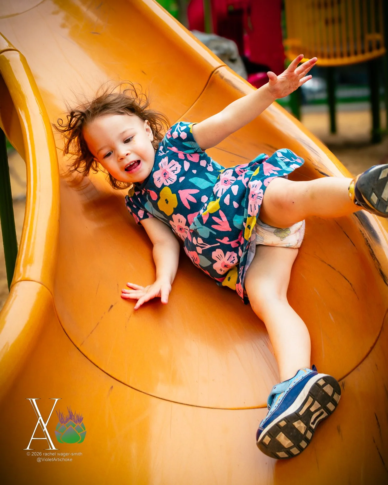 Young Girl At Bottom of Orange Slide