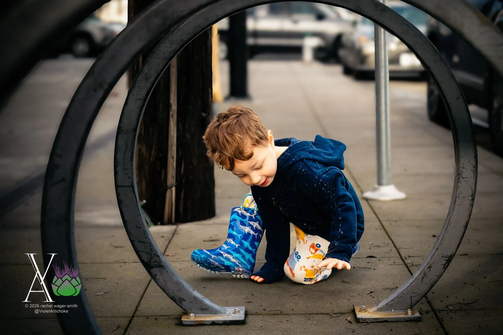 Young Boy Sits at Bike Rack