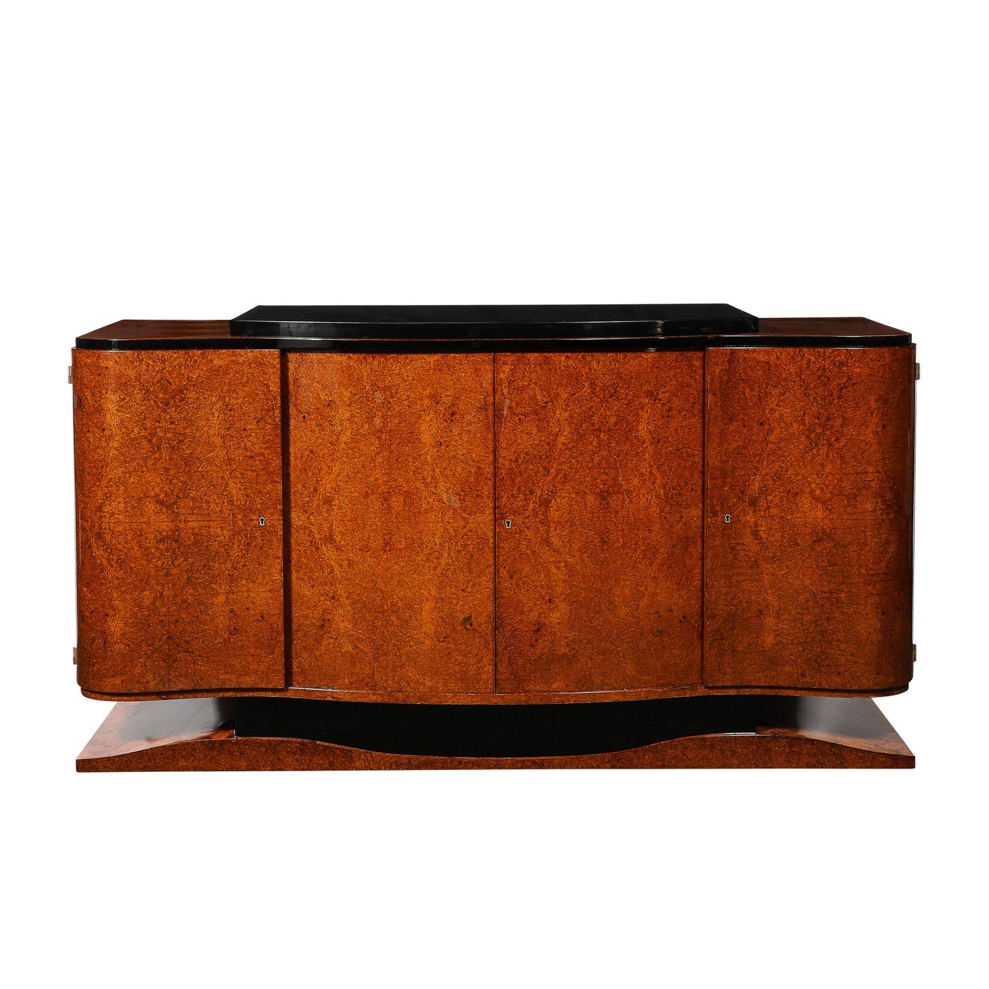 Art Deco Sideboard in Burled &amp; Bookmatched Amboyna Wood w/ Black Lacquer Detail

This elegant and exquisitely made Art Deco Sideboard in Burled and Bookmatched Amboyna Wood W/ Black Lacquer Detailing and Plinth Base originates from France, Circa 