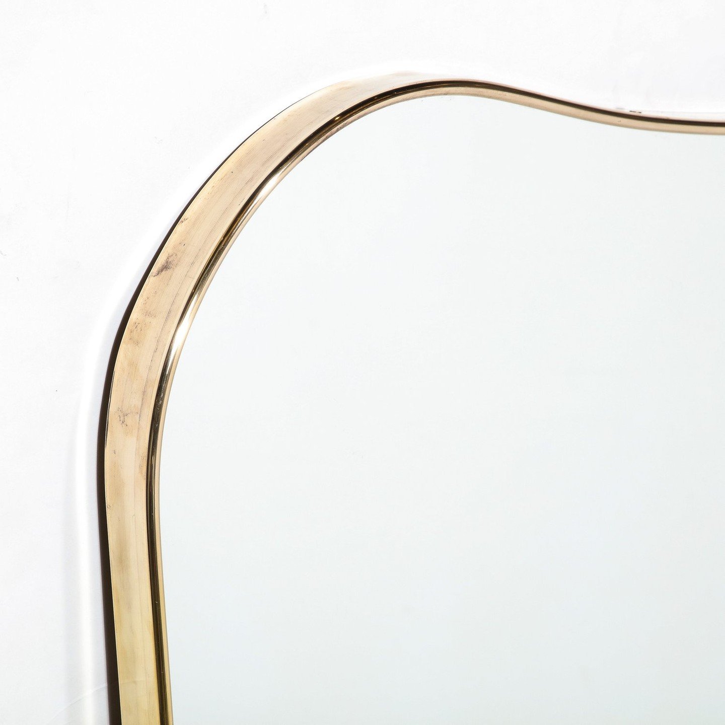 Mid-Century Modernist Shield Form Polished Brass Wrapped Mirror

This lovely Mid-Century Modernist Shield Form Polished Brass Wrapped Mirror Originates from Italy, Circa 1950. Features a curvilinear heraldic shield form profile with raised &amp; roun
