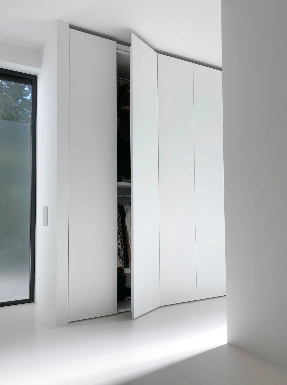 Afbeelding van een design kledingkast met een deur half open.