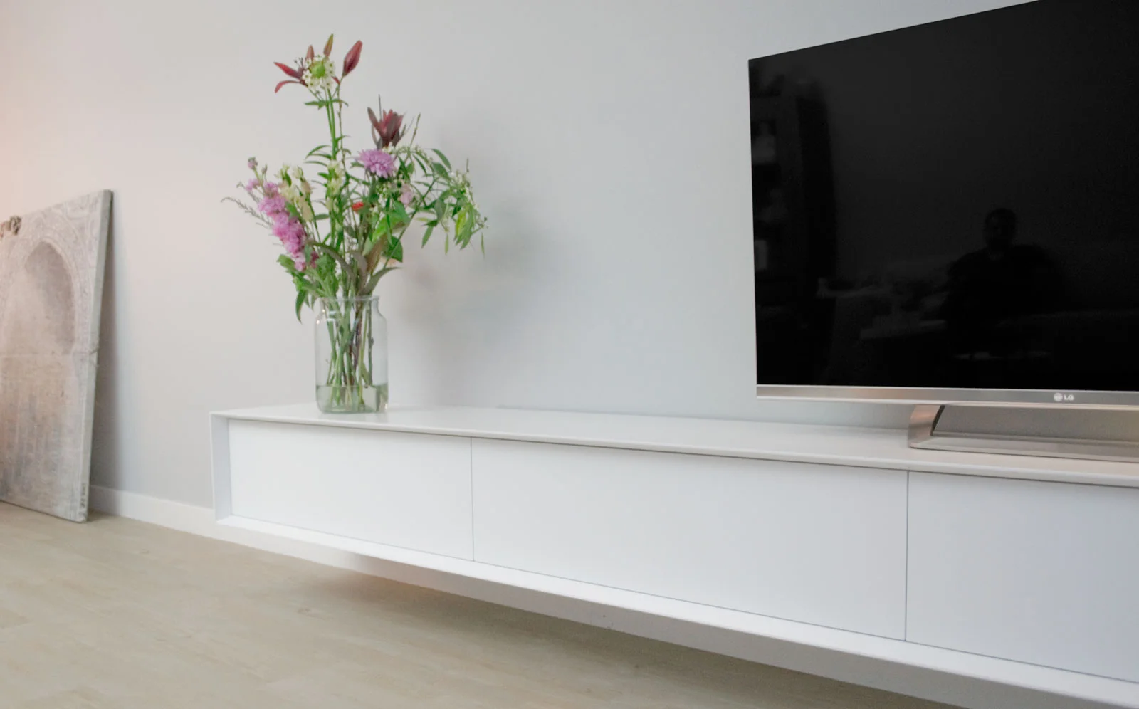 Afbeelding van een wit design TV meubel vanuit een perspectivische hoek gefotografeerd.