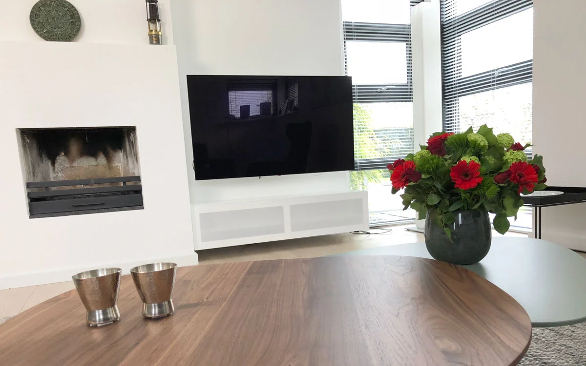 Afbeelding van een wandpaneel TV meubel gefotografeerd over een notenhouten salontafel.