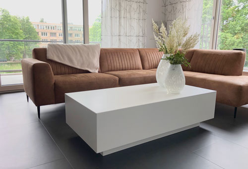 Salontafel met vazen, bruine lederen bank.