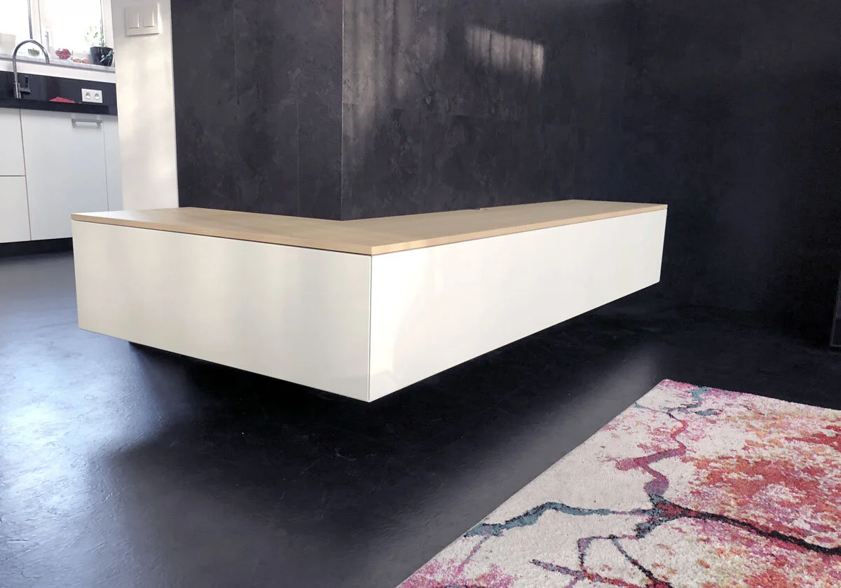 Design TV meubel om een buitenhoek, wit, eiken, donkere wand en vloer, kleurig vloerkleed
