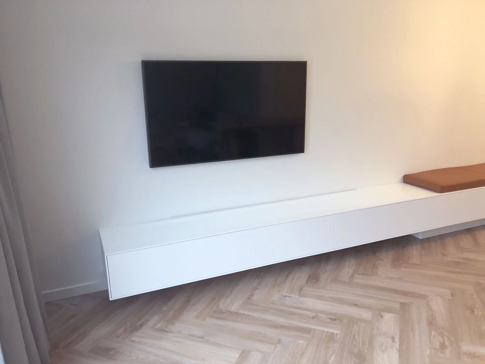 Extra lang wit TV-meubel op maat met geïntegreerde zitbank