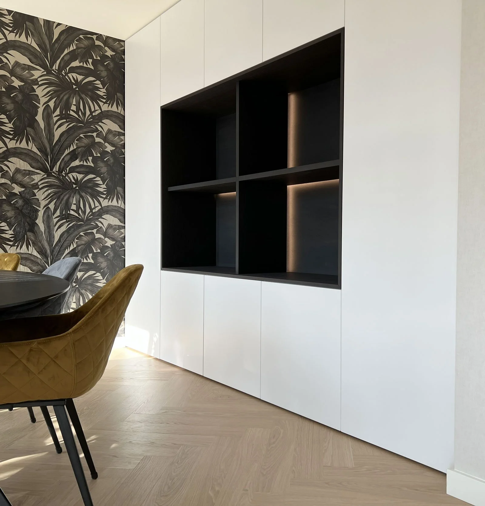Kastenwand in nis met donker gebeitst open vak en ledverlichting, vanuit een andere hoek