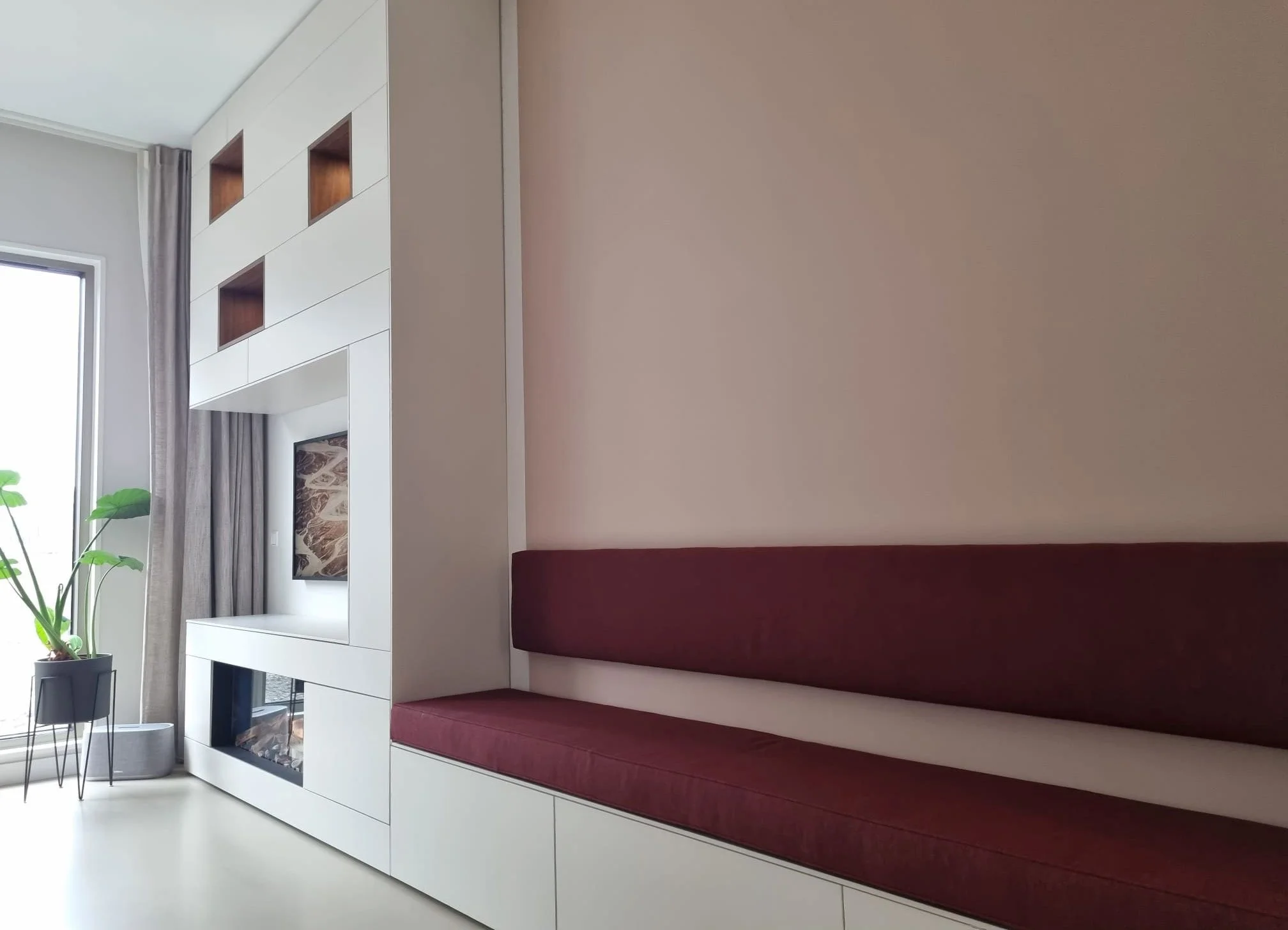 Detail van kastenwand met noten fineer, elektrische haard en geïntegreerde zitbank