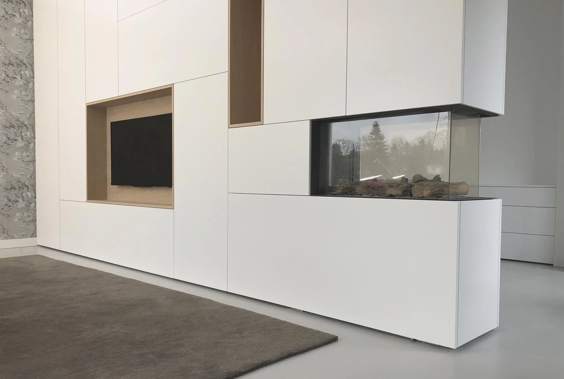 Kastenwand als roomdivider met tv-vak, open vakken en geïntegreerde haard