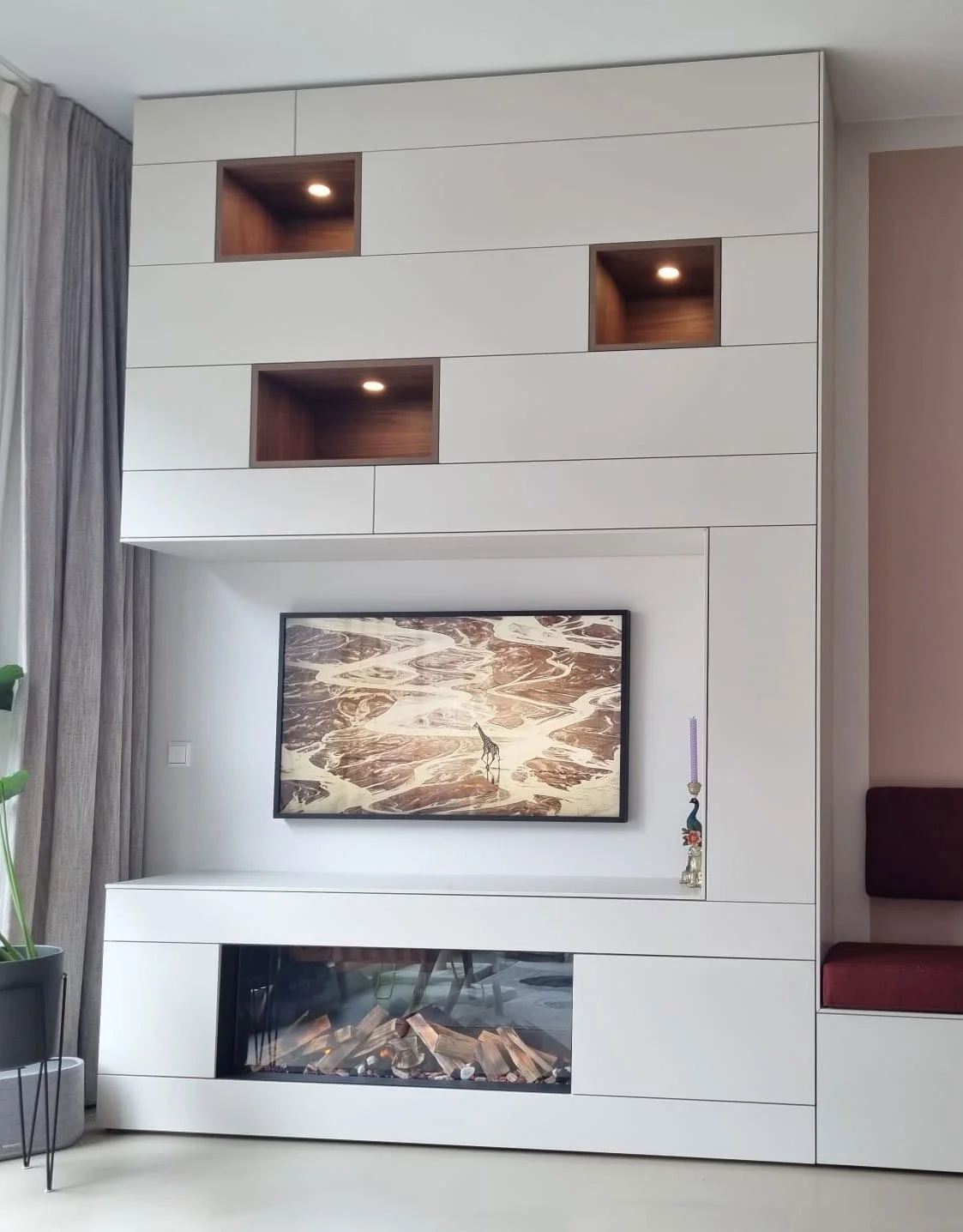 Kastenwand op maat met open vakken in noten fineer, tv en een elektrische haard