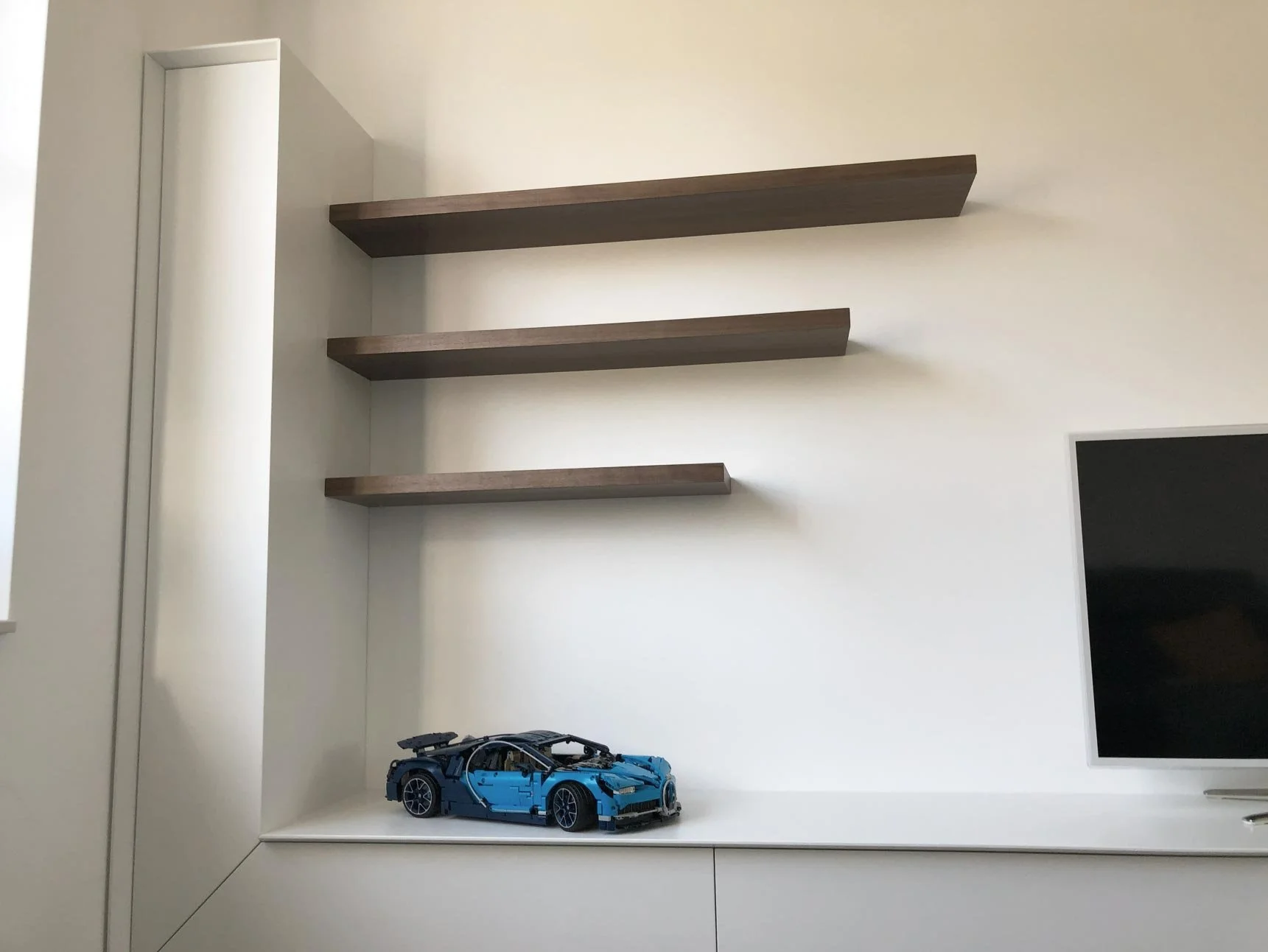 Detailafbeelding van een TV-meubel op maat met noten fineer zwevende schappen.