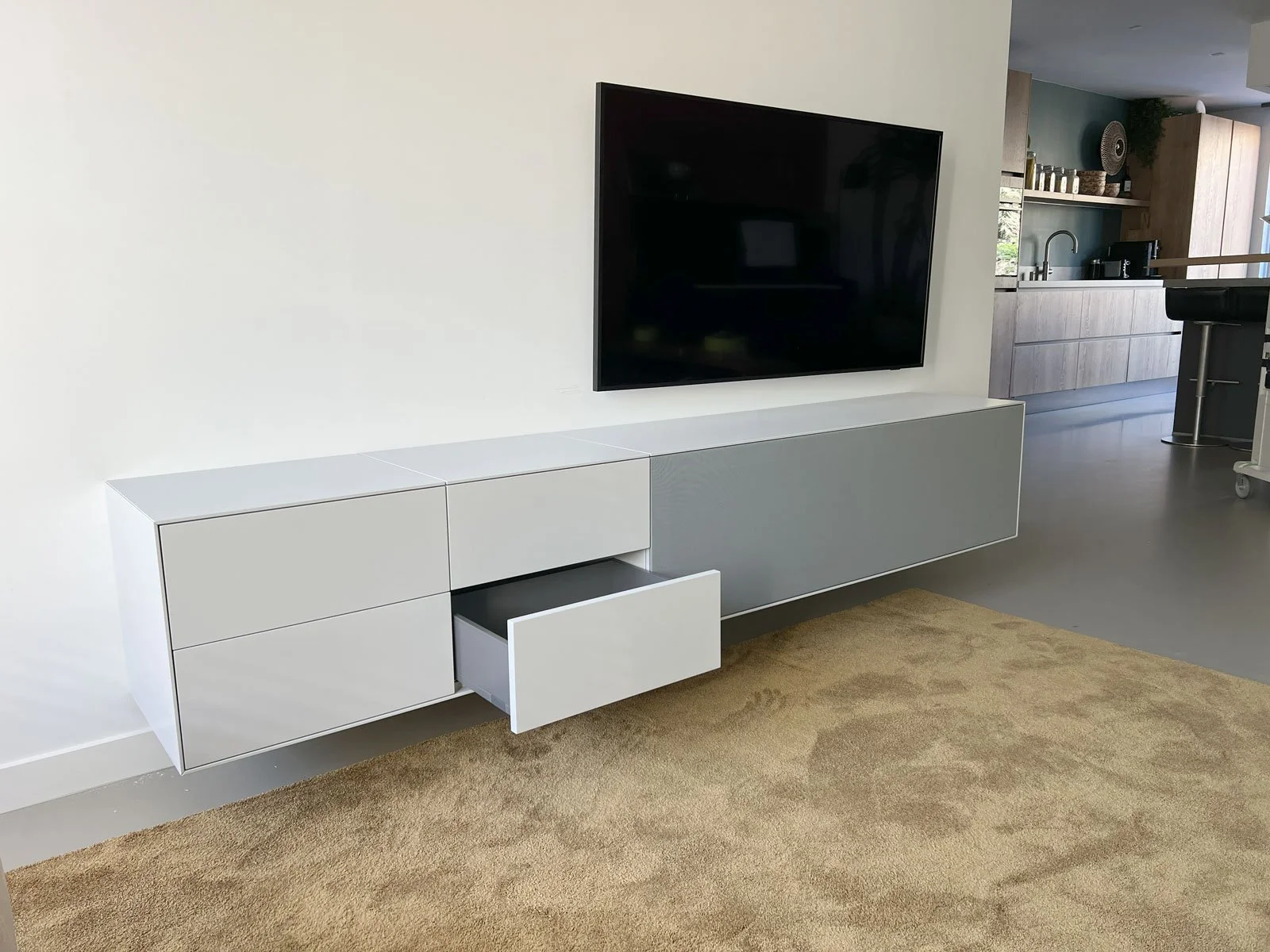 Zwevend TV-meubel met open lade onder wand-TV