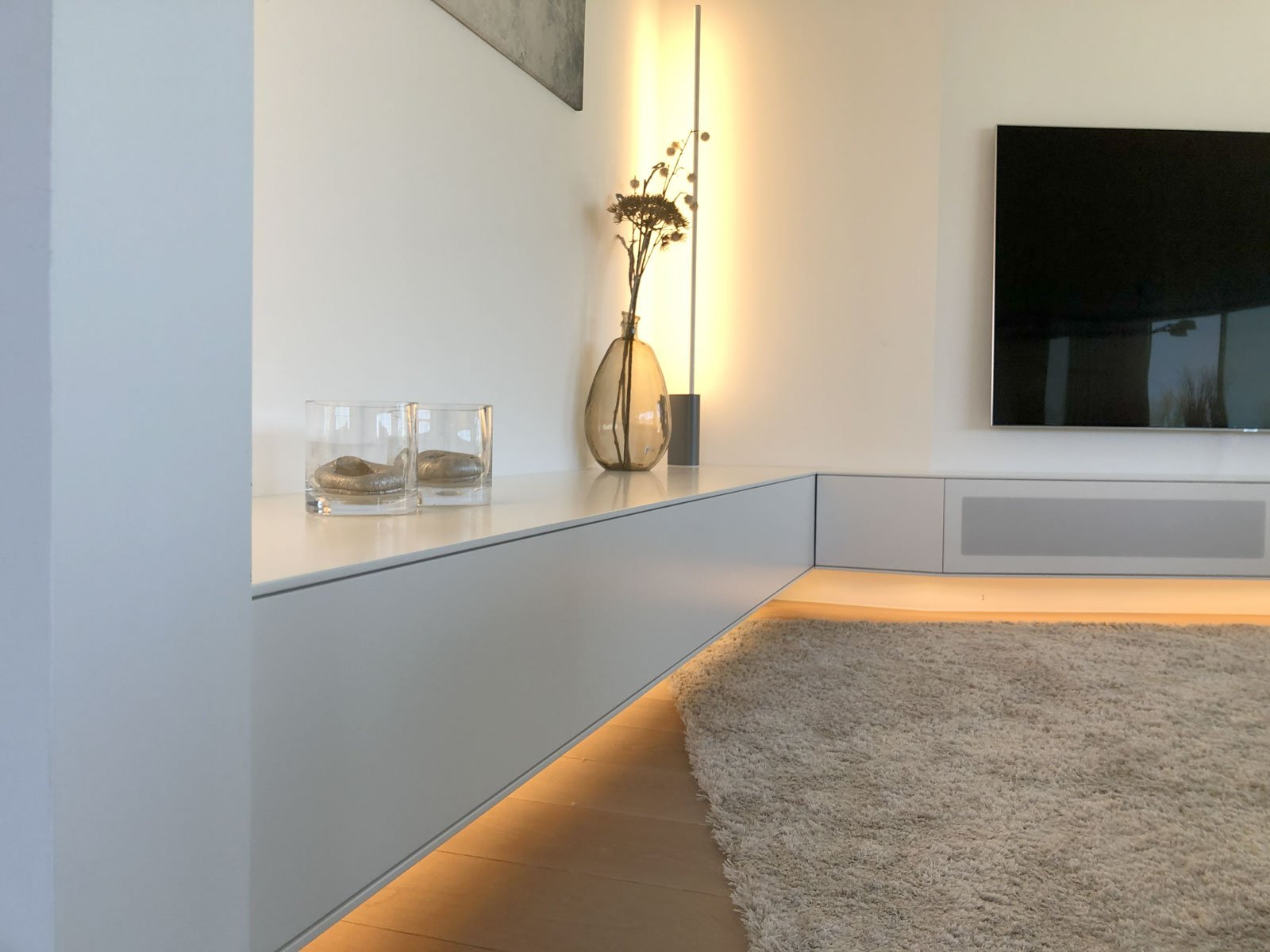 Detail van zwevend TV-meubel met indirecte LED-verlichting