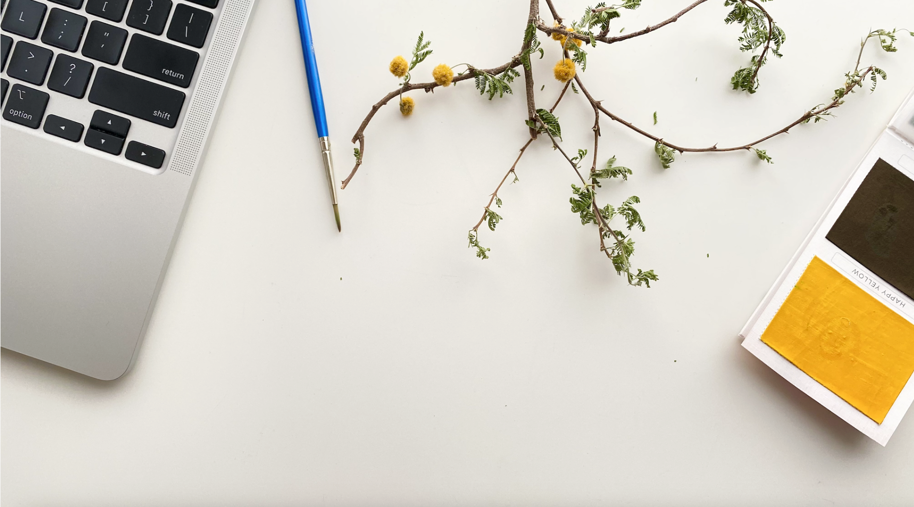 Laptop and paint set on studio table.