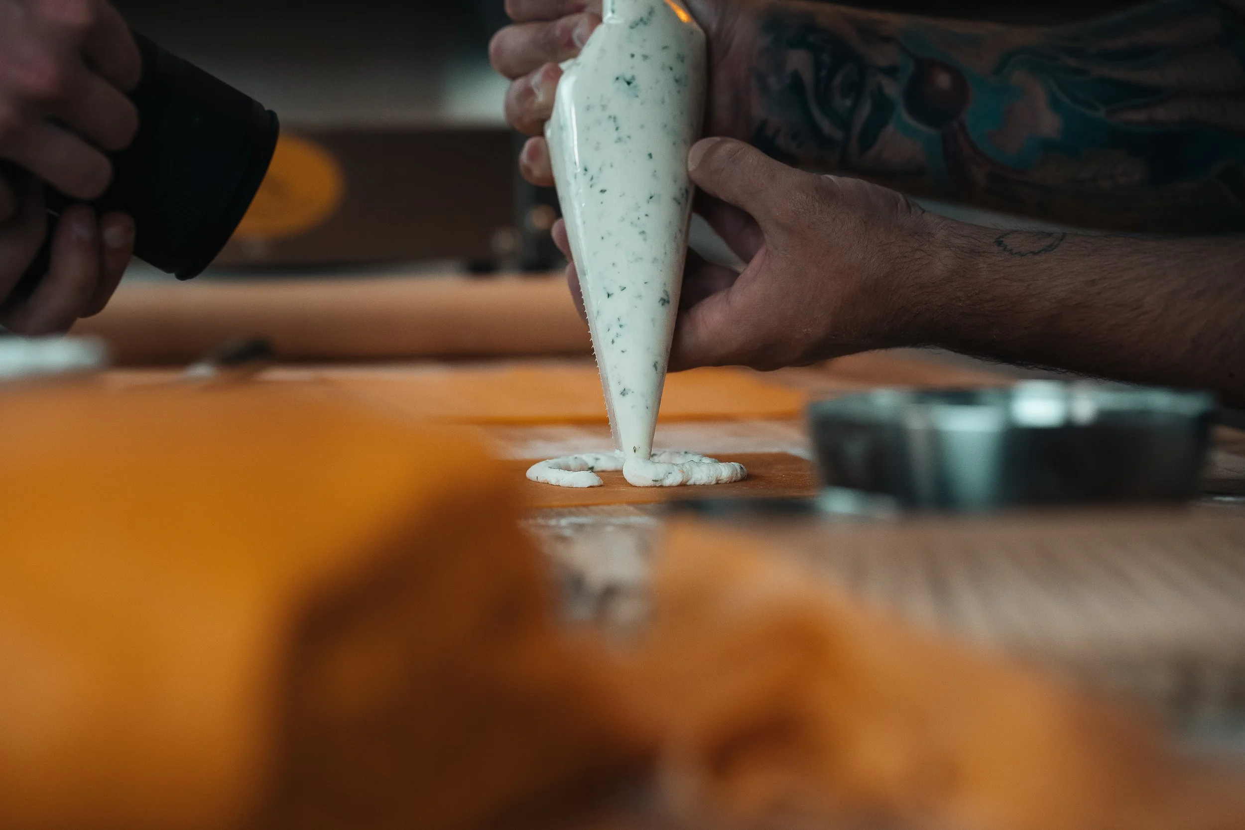 Chef in Pittsburgh restaurant piping sauce onto pasta captured by Ian Jones, food photographer for chefs and restaurants