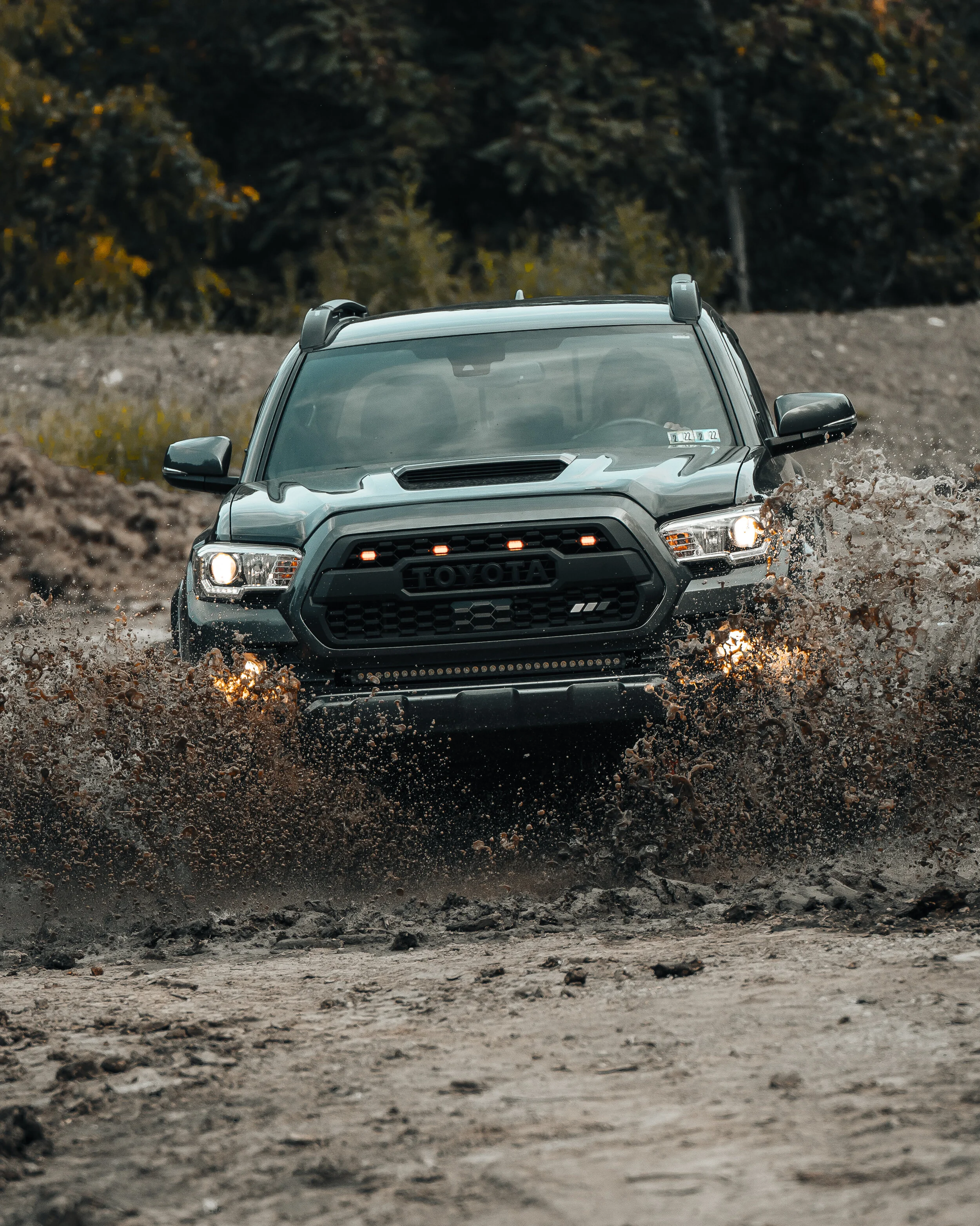 Rear detail of a 2019 Toyota Tacoma TRD Sport build showing AlphaRex jet-black taillights, TRD 4x4 Sport bedside graphic, rear bumper, exhaust tip, and off-road stance photographed by Ian Jones for ISJDESIGNS.