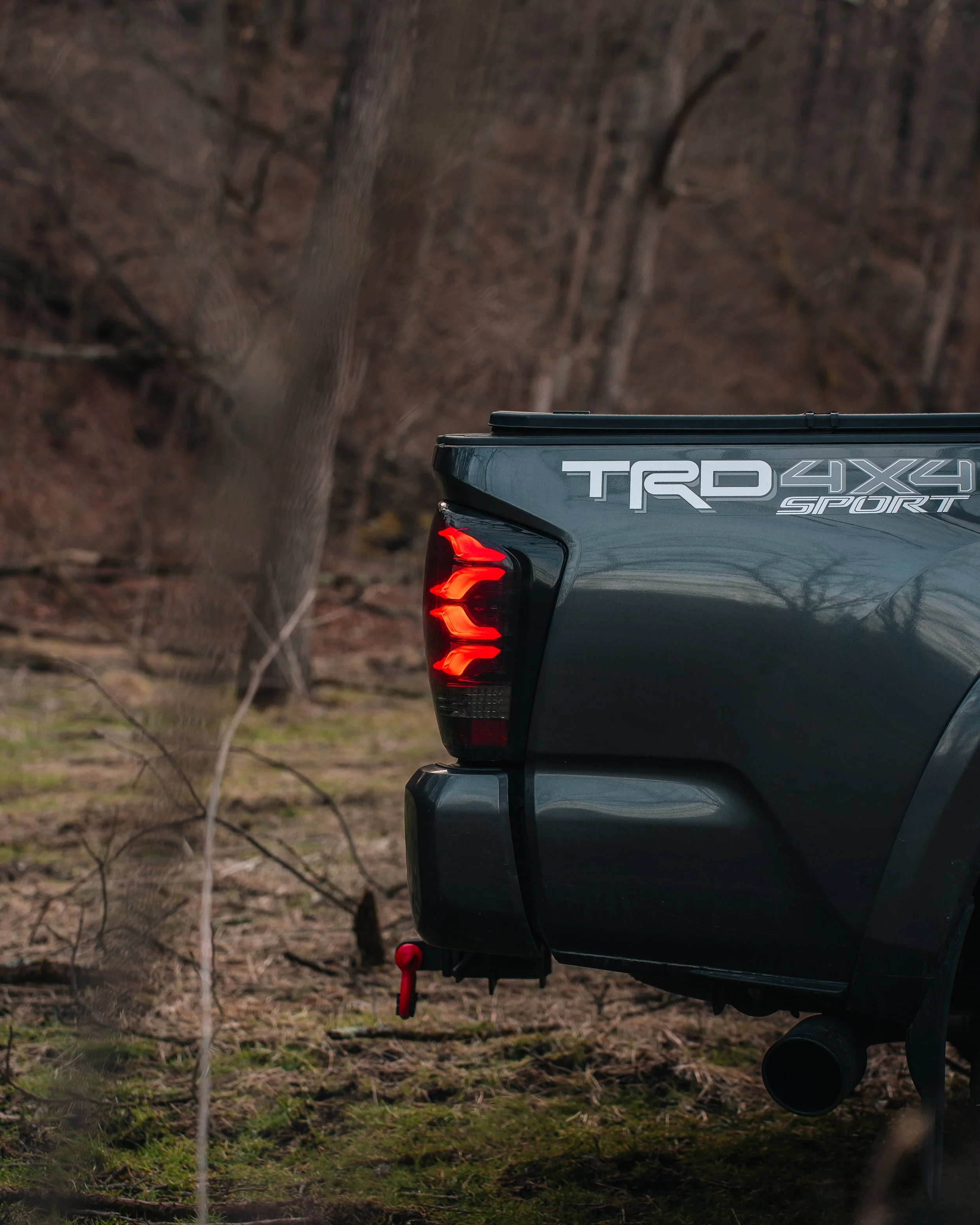 2019 Toyota Tacoma TRD Sport driving through deep mud with TRD Pro grille, raptor lights, front light bar, fog lights, and off-road splash action photographed by Ian Jones for ISJDESIGNS.