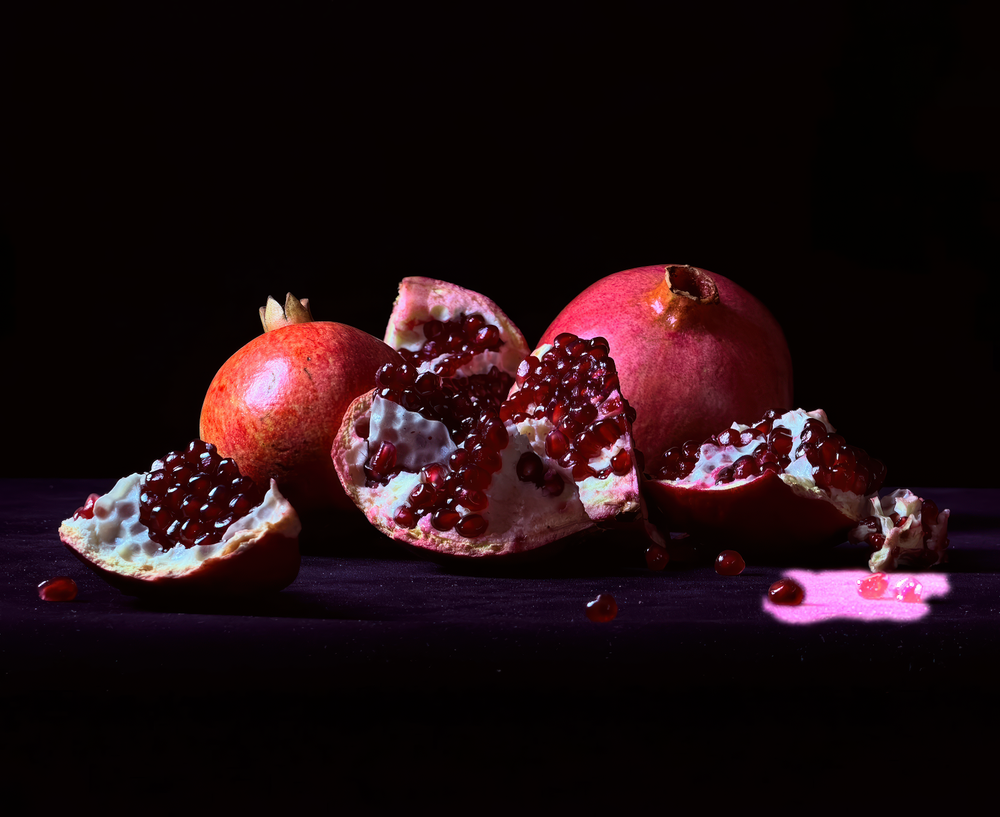 Apple-supplied iPhone 17 Pro sample still life of pomegranates, showing color accuracy, fine texture, highlight detail, tonal depth, and close-range subject rendering.