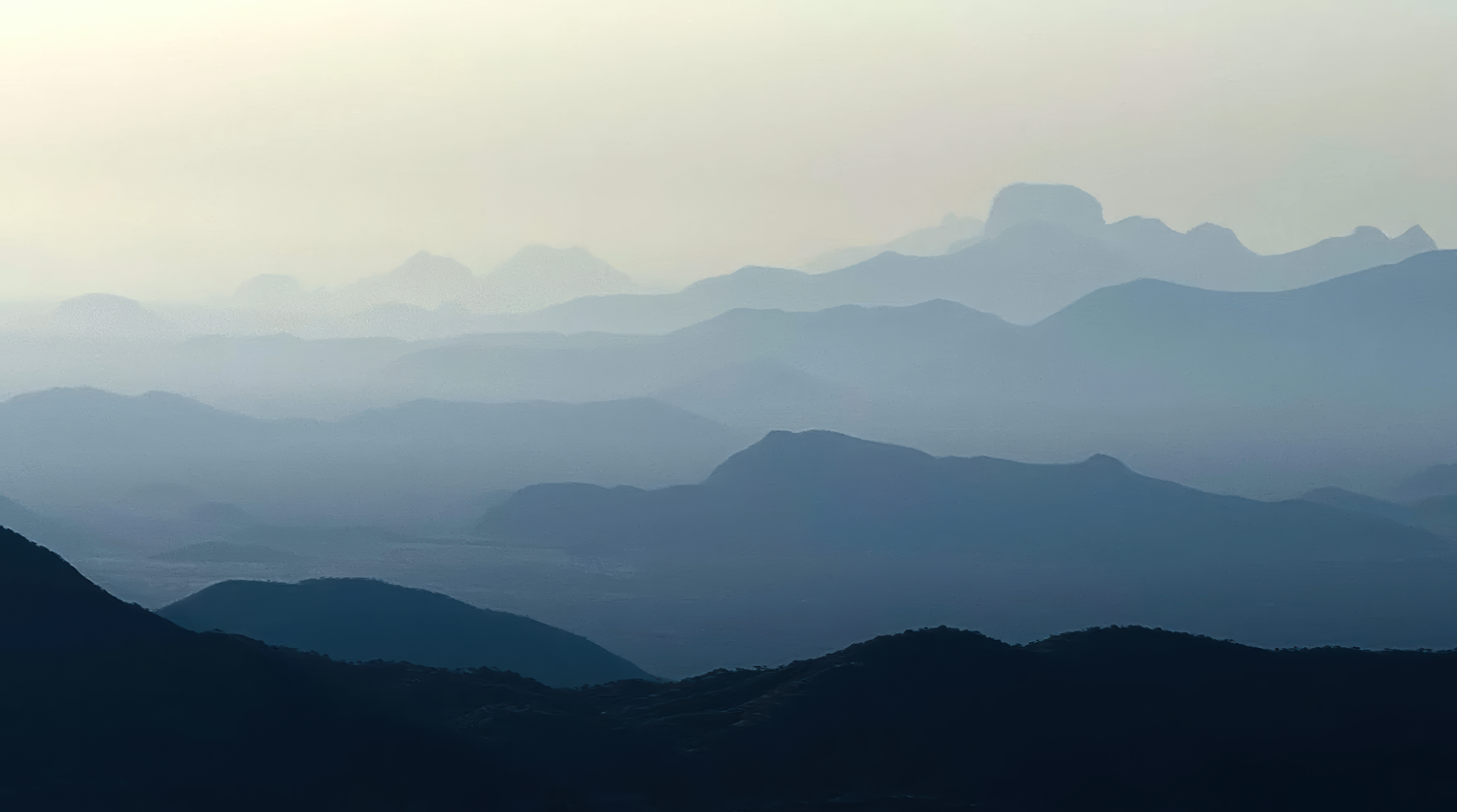 Apple-supplied iPhone 16 Pro telephoto sample photo of layered mountain ridges, demonstrating long-lens compression, atmospheric depth, tonal separation, and distant landscape detail.