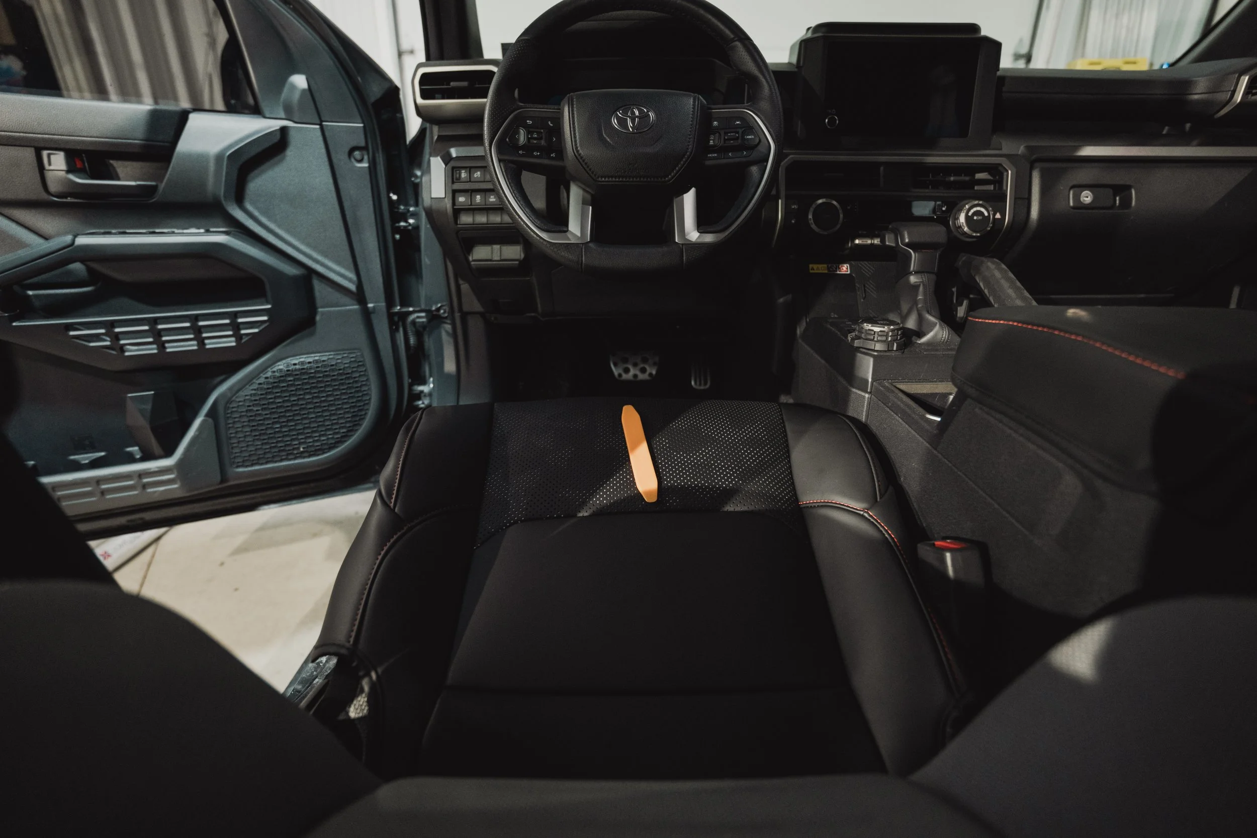 Installer fitting Lexland full coverage camo black nappa leather seat covers in a 2025 Toyota 4Runner during installation — photo by Ian Jones, ISJDesigns