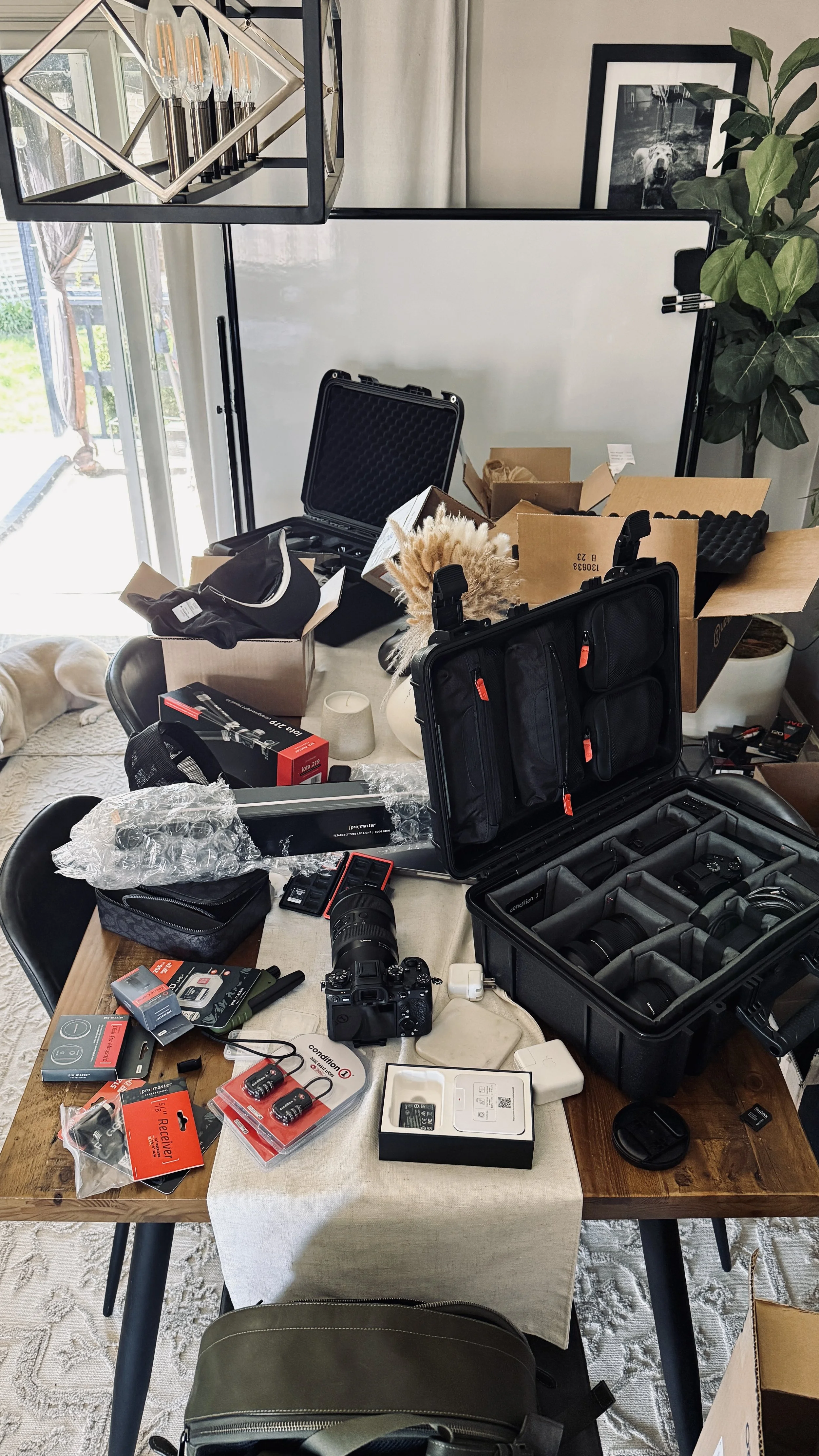 Camera gear, Condition1 hard cases, and packaged products spread across a table at the ISJDESIGNS studio in Bridgeville PA — showing what a proper product photography collaboration looks like when brands ship gear to photographer Ian Jones