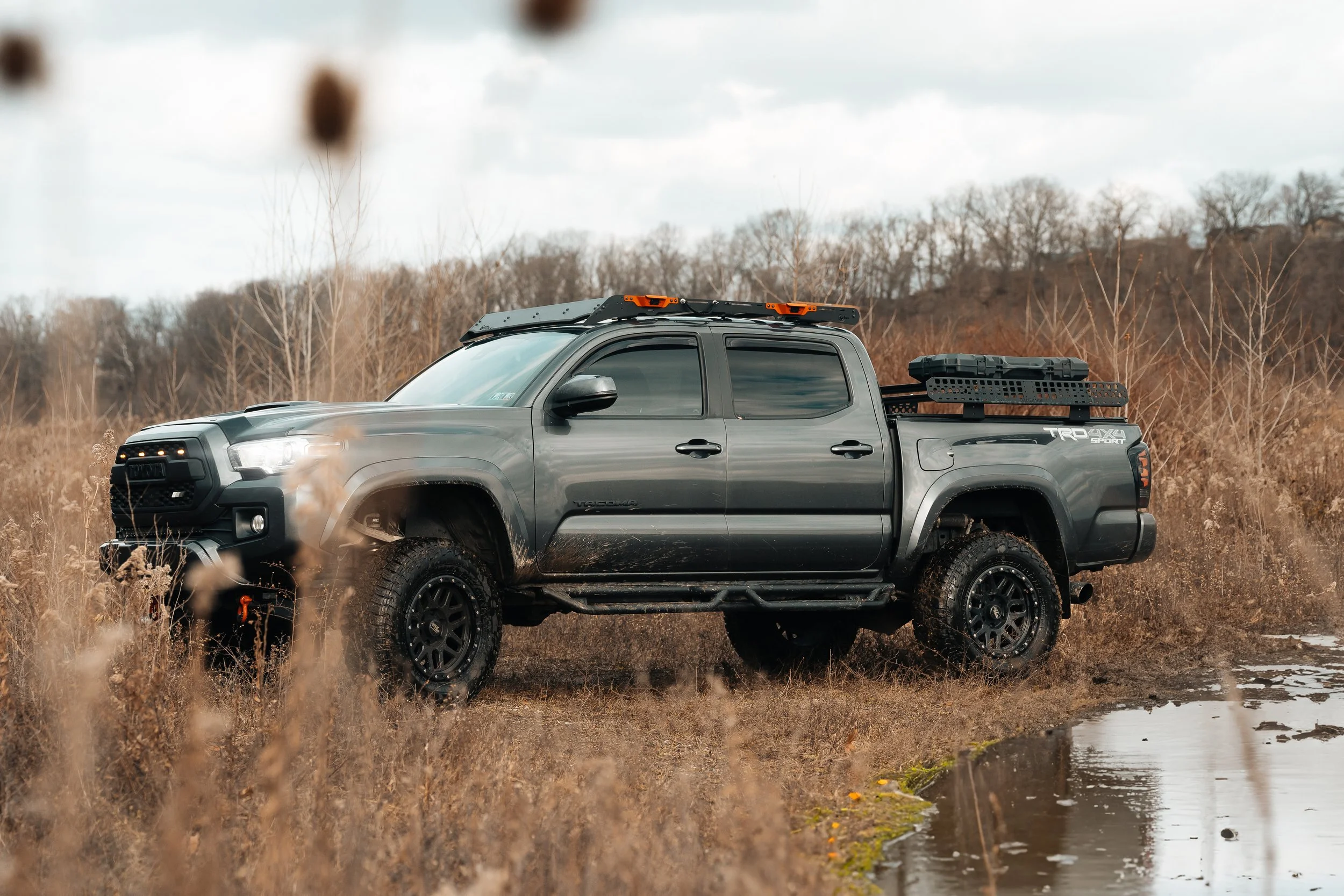 Side view of a 2019 Toyota Tacoma featuring a Prinsu roof rack and Billie Bars bed rack, shot off-road for adventure-ready versatility, photographed by Ian Jones for ISJDESIGNS.