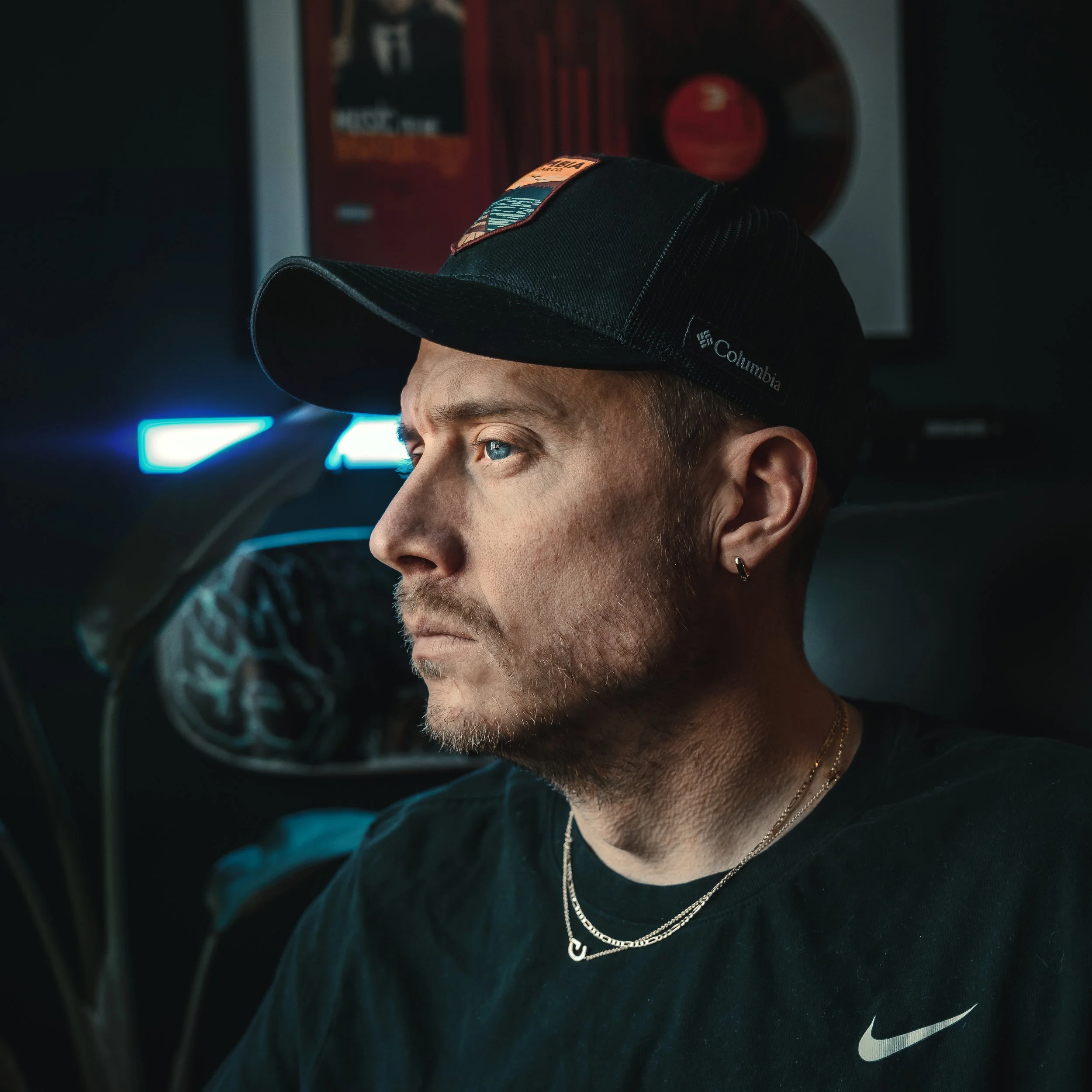 Ian Jones Pittsburgh photographer and content creator in his studio, professional portrait wearing a black cap and chain, focused while working on creative projects
