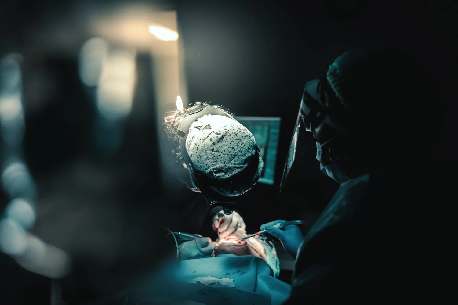 Surgical procedure with loupes and headlamp, Pittsburgh oral surgery photography by Ian Jones