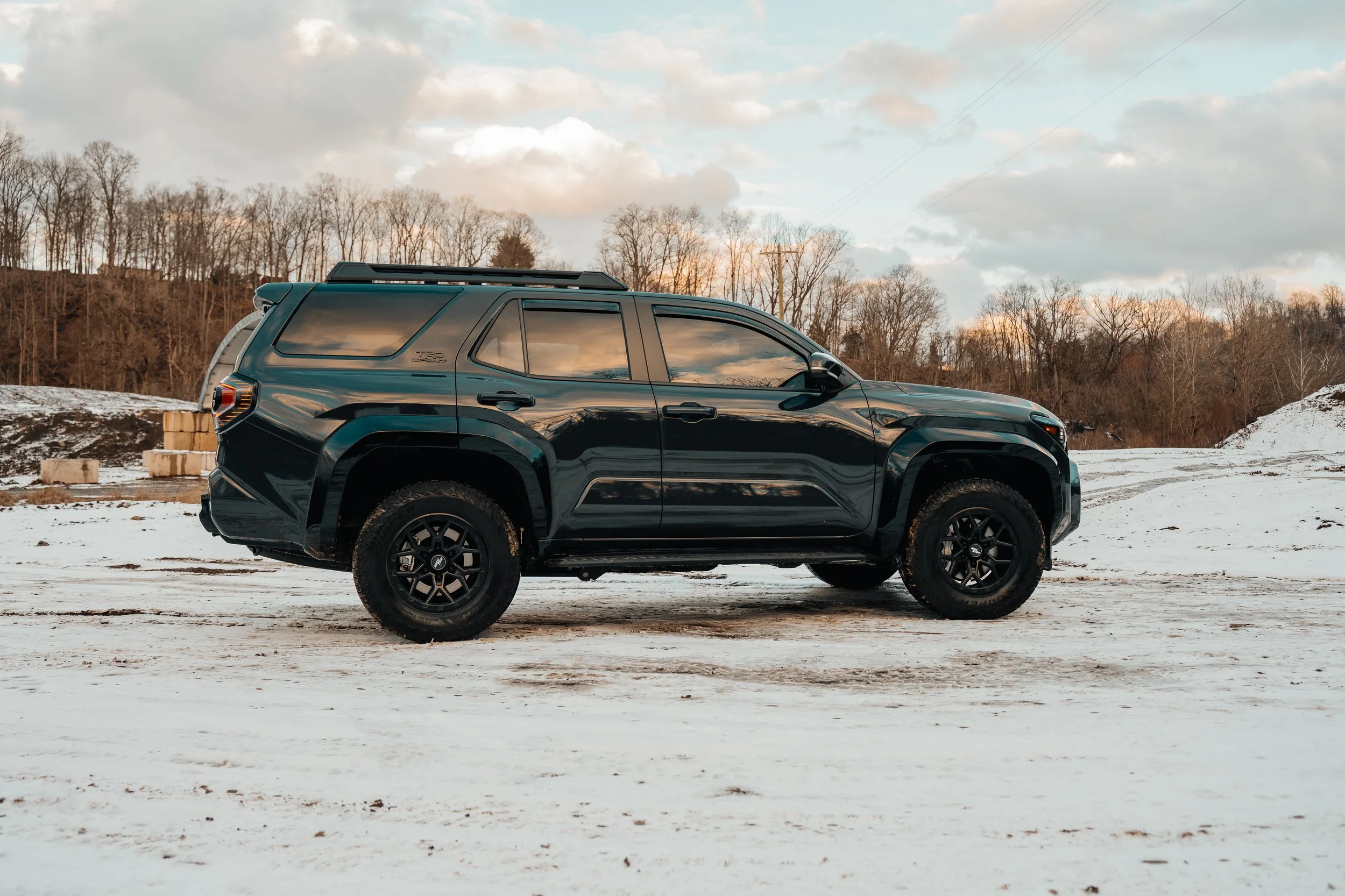 Side profile of a 2025 Toyota 4Runner TRD Sport on a snowy lot at sunset, showcasing RockTrix wheels and all-terrain tires — taken by Ian Jones of ISJDESIGNS in Pittsburgh, PA.