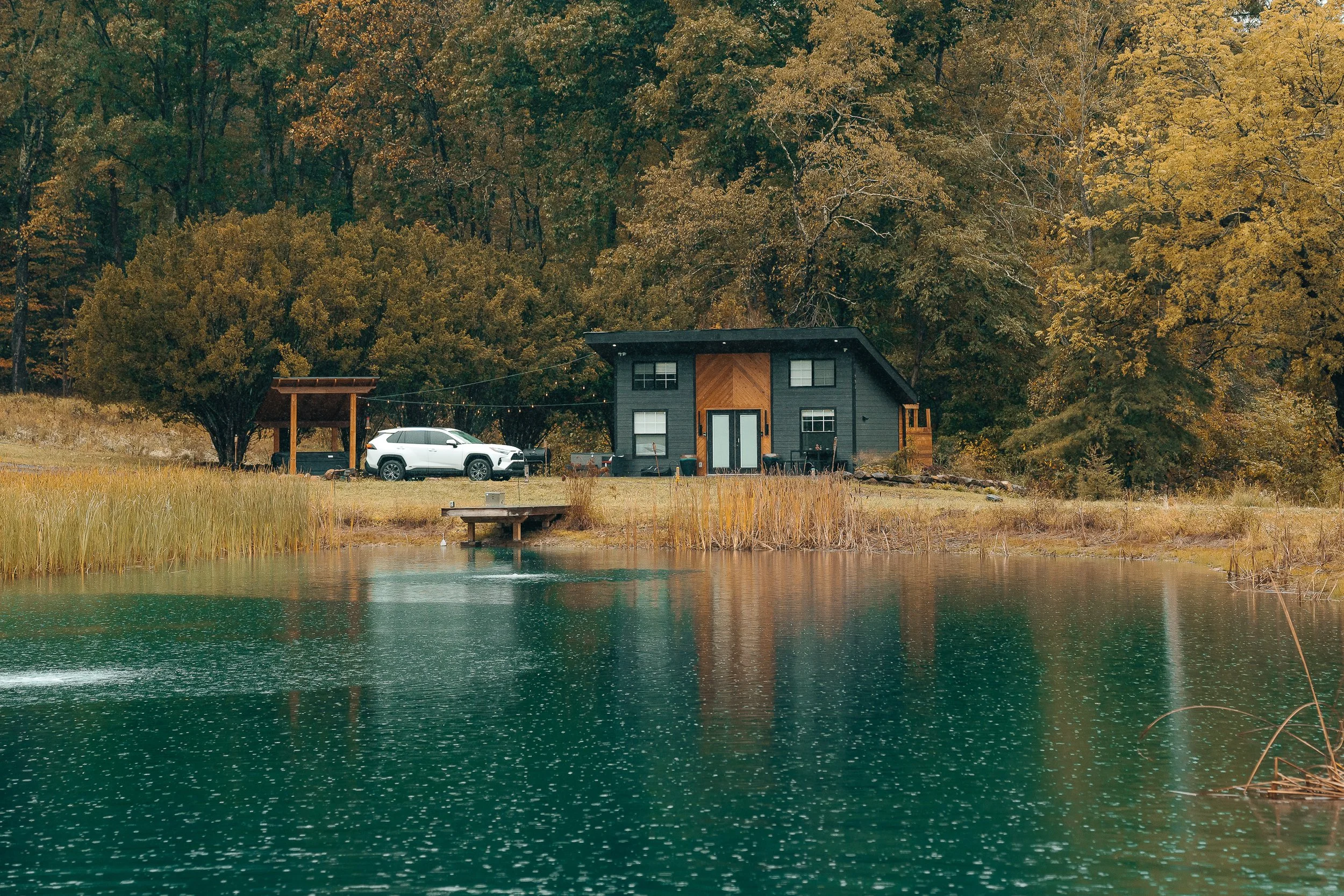 Cinematic Airbnb and lifestyle photography of modern cabin with SUV parked by lake in Pittsburgh by Ian Jones