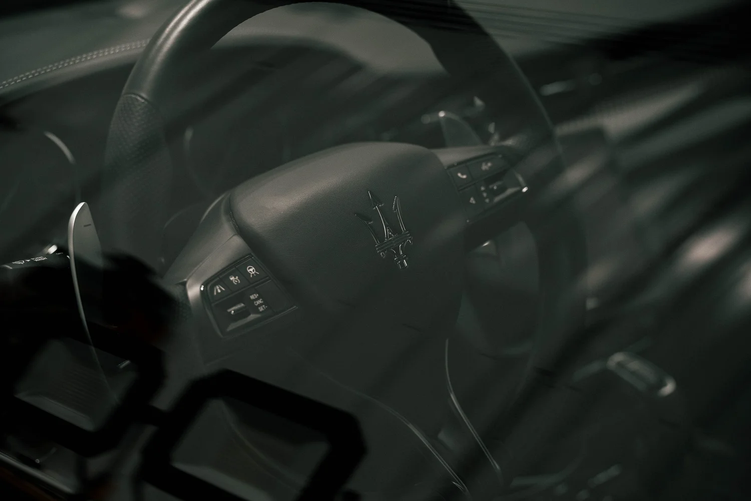 Maserati steering wheel and trident badge photographed through the window, Ian Jones Pittsburgh luxury automotive photography by ISJDESIGNS