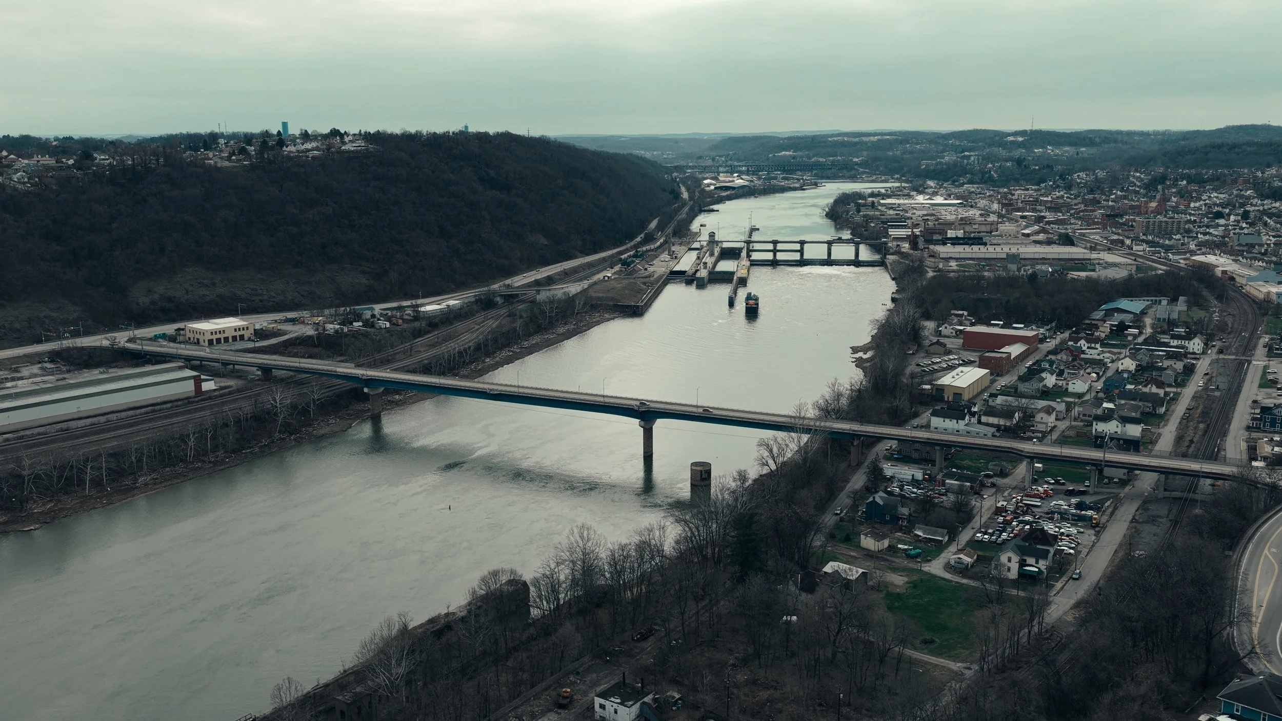 Western PA aerial drone photography by Ian Jones showing the Monongahela River, Lock 4, bridges, industrial property, and a barge near Charleroi Pennsylvania.