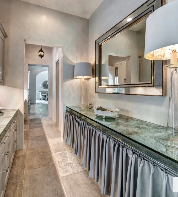 The glistening of mirrored glass counters married with aged stone floors and an antique lantern creates unexpected details and makes the room feel like you are unwrapping a present as you enter it. Photo by Michael Hunter