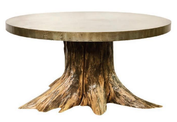 A truly unique and one-of-a-kind table, this piece features a wood stump recovered from the Mississippi River paired with the sheet steel made in India that has an antique pantina. Photography by Ashlee Nobel and courtesy of Paul Michael Company