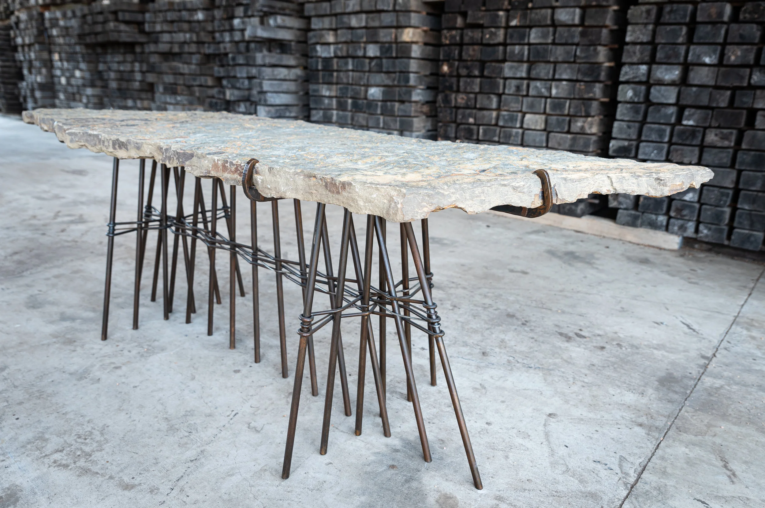 Photo by Ashlee Nobel This solid slab table was made from stone harvested from the Ozarks in Northwest Arkansas and has a custom metal base.