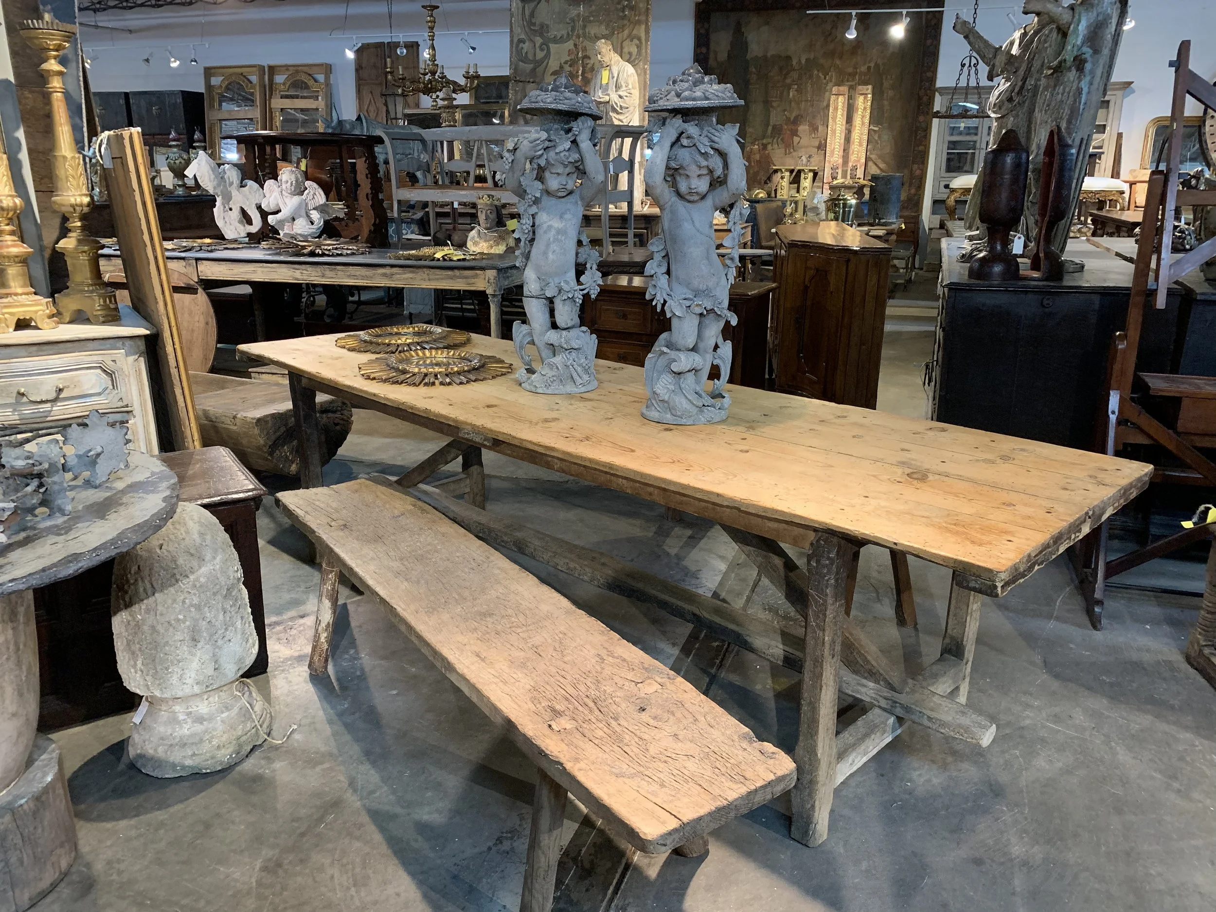 Photos courtesy of Provenance Antiques A French 18th-century primitive farm table with benches with a pair of 19th-century zinc Putti from the Provence region of France