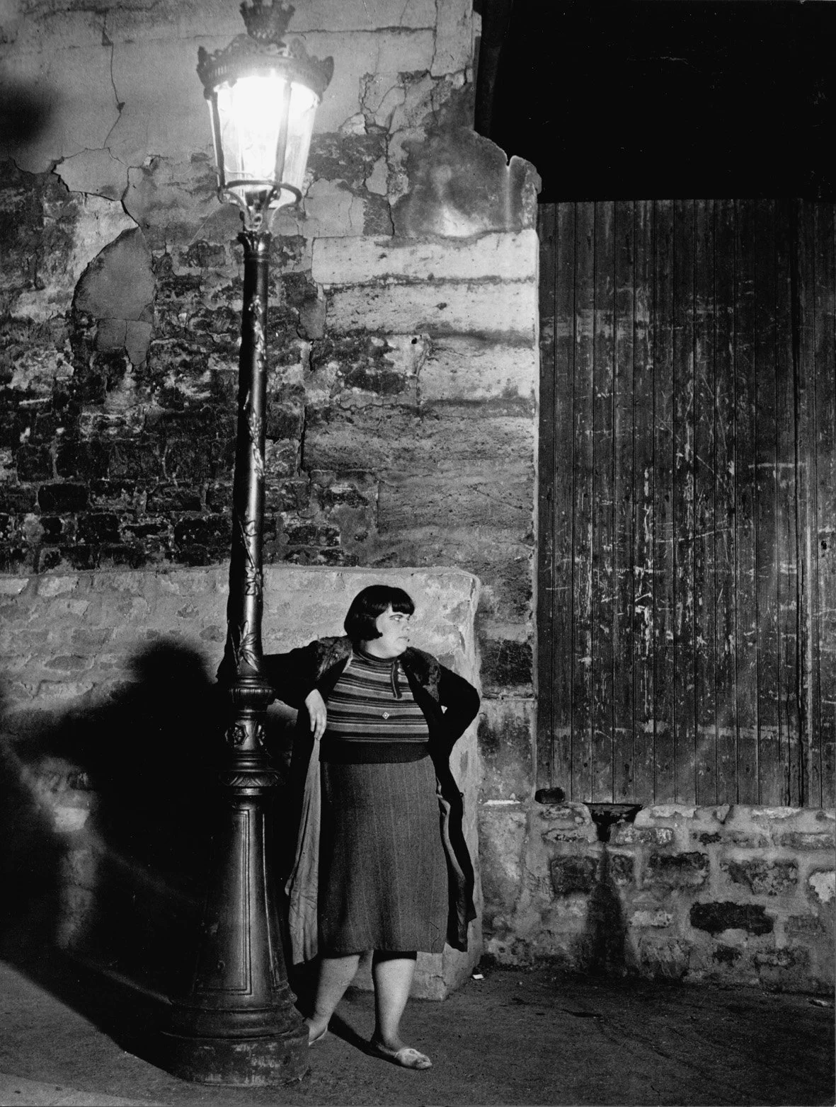   UNE FILLE DE JOIE  Gelatin silver print. Ca. 1932. Printed later. Signed and with the photographer's copyright stamp on the verso. On  Agfa . 300 × 228 mm 