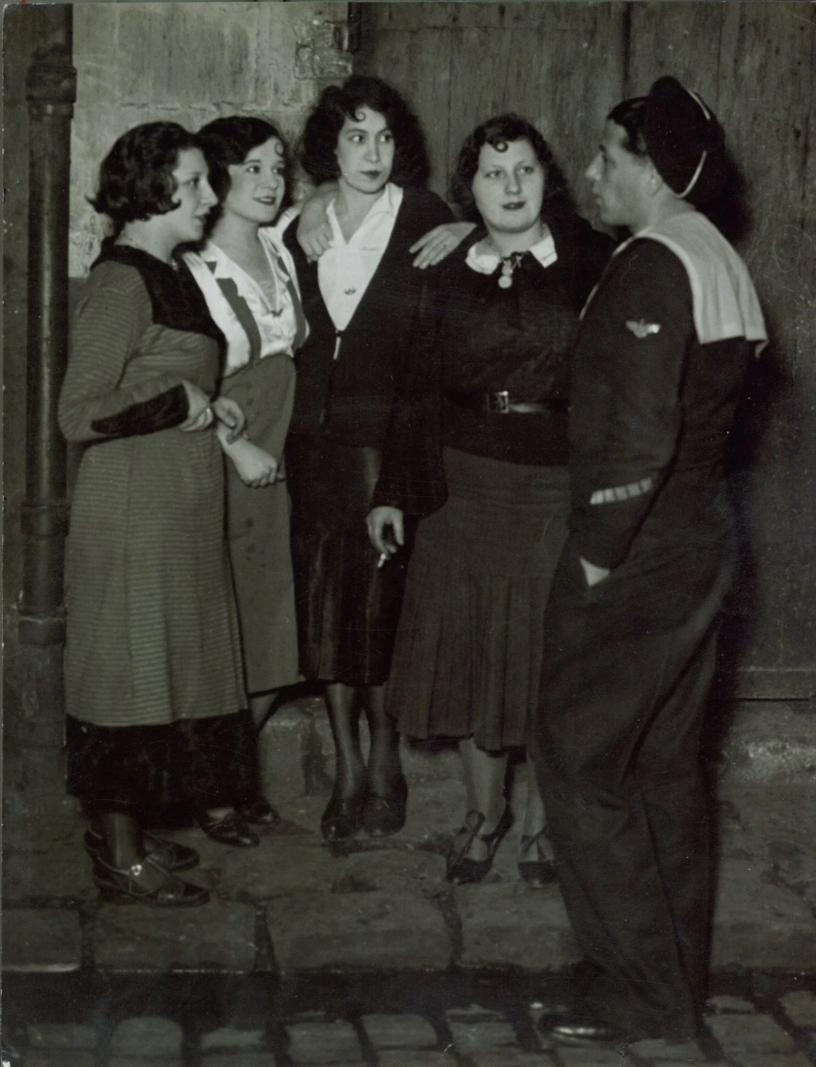   MARIN EN BORDÉE, RUE DE LAPPE  Gelatin silver print. Ca. 1932. Ferrotyped, printed presumably in the 1940s. Signed, titled, dated, stamped and annotated. 239 × 178 mm. 