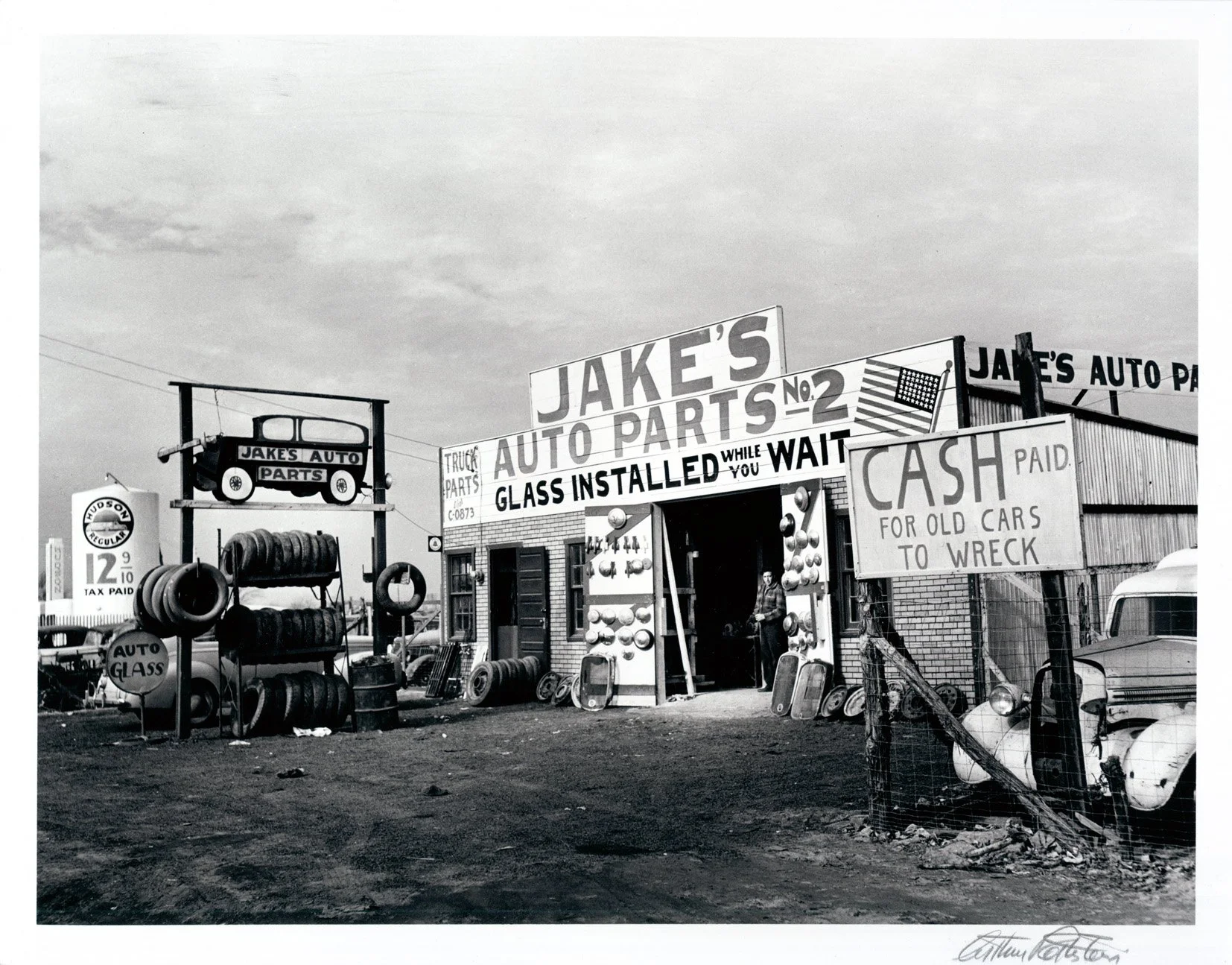   JAKE'S AUTO PARTS  Gelatine silver print. 1942. Printed later. Signed, titled and dated. 252 × 330 mm (276 × 355 mm) 