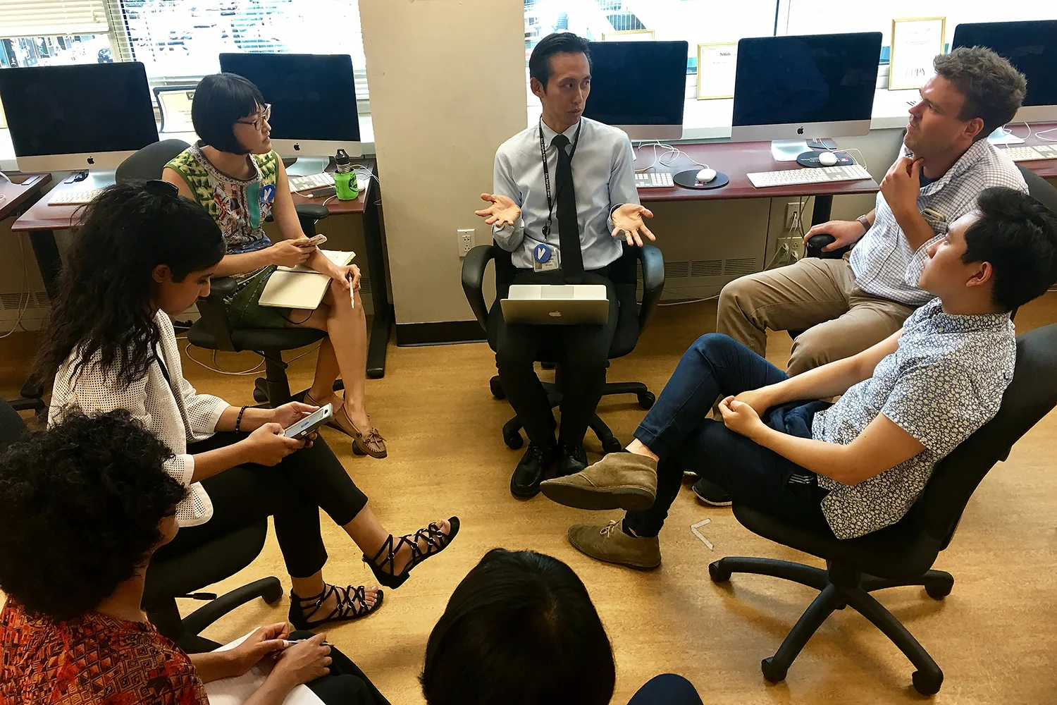 Voices mentor Ron Lin checks in with his story group during the first on-site day of Voices in Philadelphia at the Temple University multimedia lab.