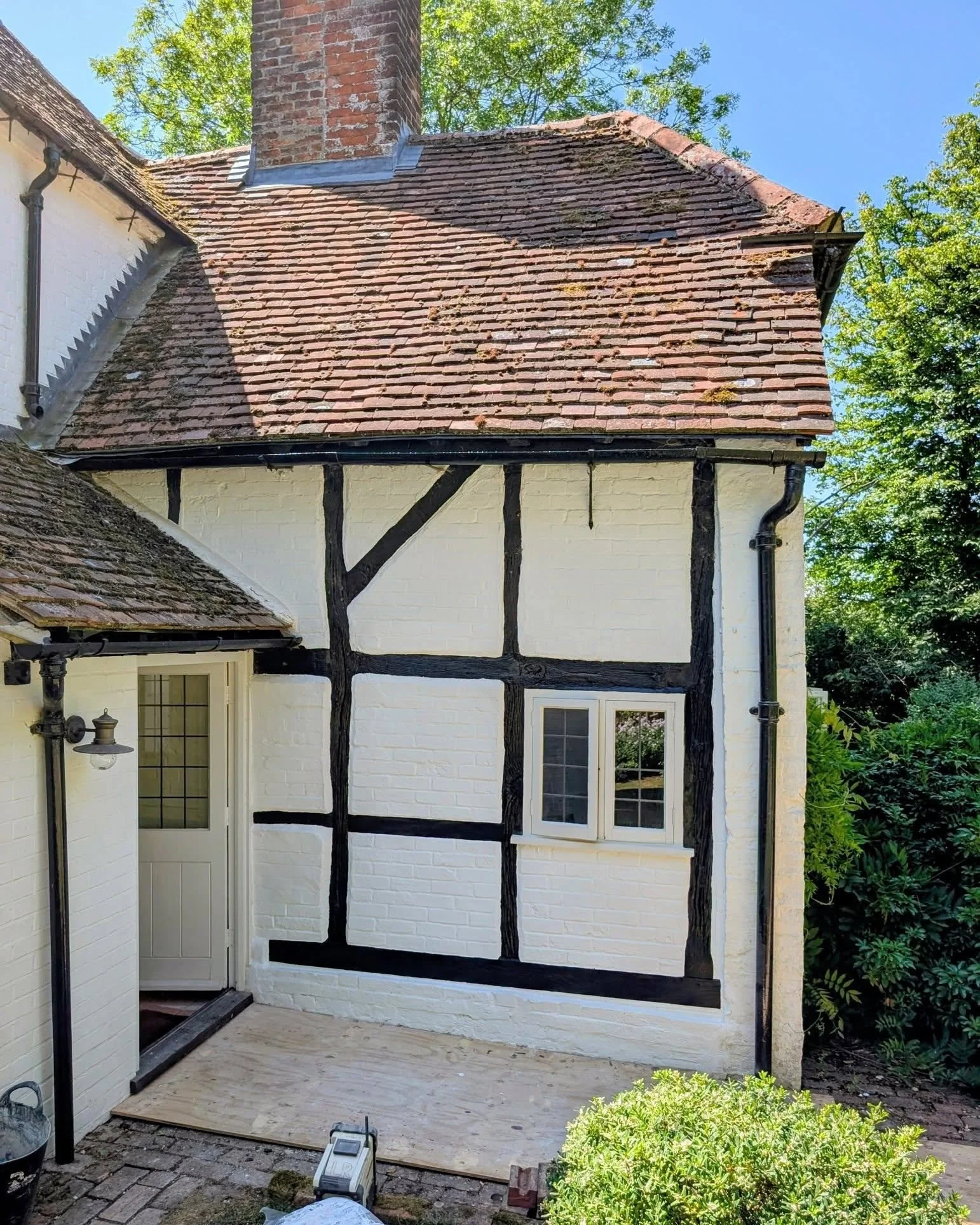 This charming late C16 cottage had been quietly struggling under layers of cement plaster and non-breathable paint&mdash;classic culprits in heritage decay.
We replaced the rotten sill plate, repaired the base of the post, and rebuilt the brick infil