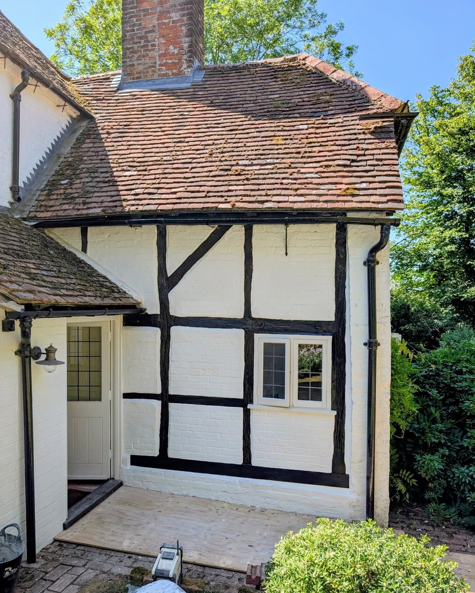 This charming late C16 cottage had been quietly struggling under layers of cement plaster and non-breathable paint&mdash;classic culprits in heritage decay.
We replaced the rotten sill plate, repaired the base of the post, and rebuilt the brick infil
